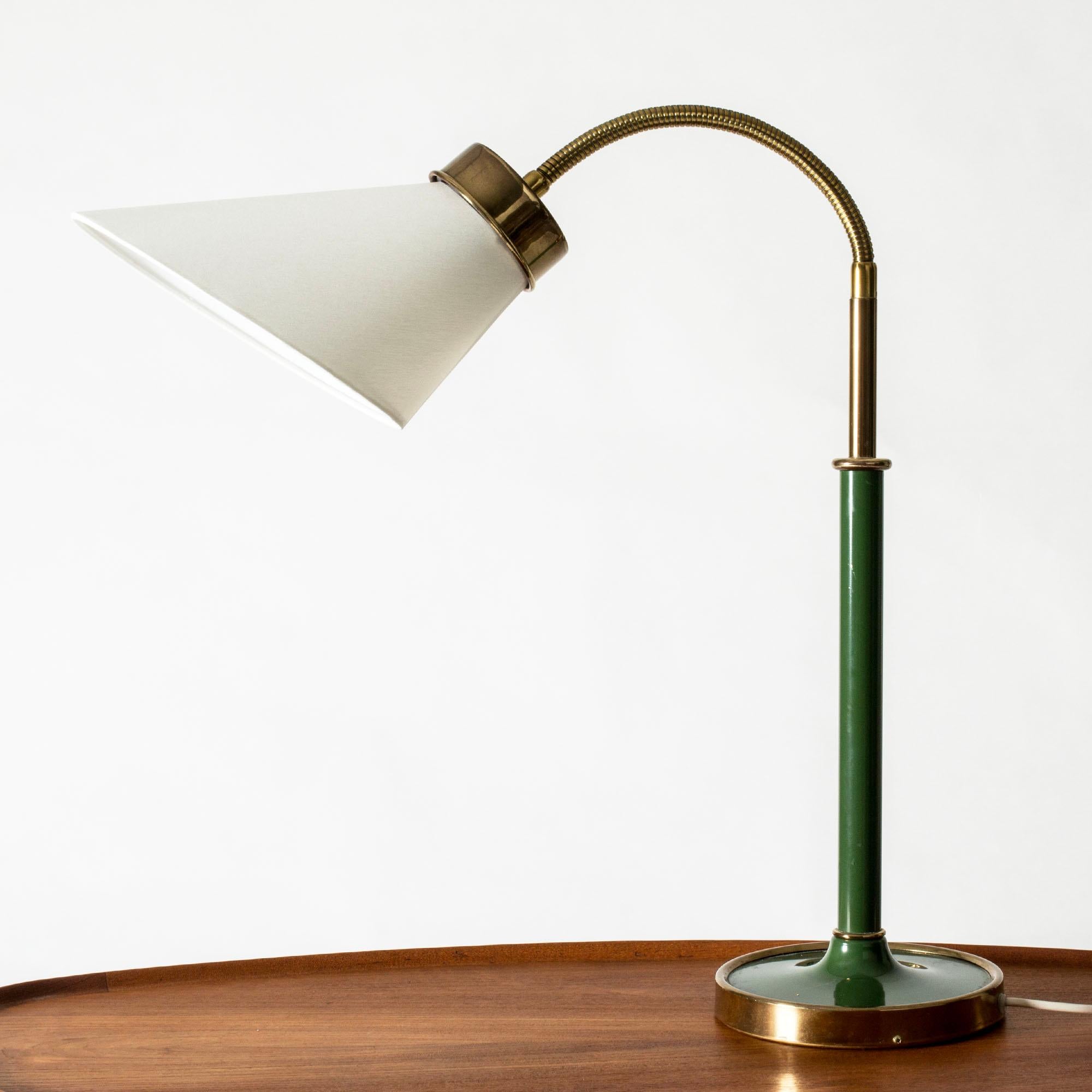 Élégante lampe de table ou de bureau en laiton de Josef Franks, avec un abat-jour asymétrique et un col flexible. Laqué vert dans une nuance qui se marie à merveille avec la chaleur du laiton.