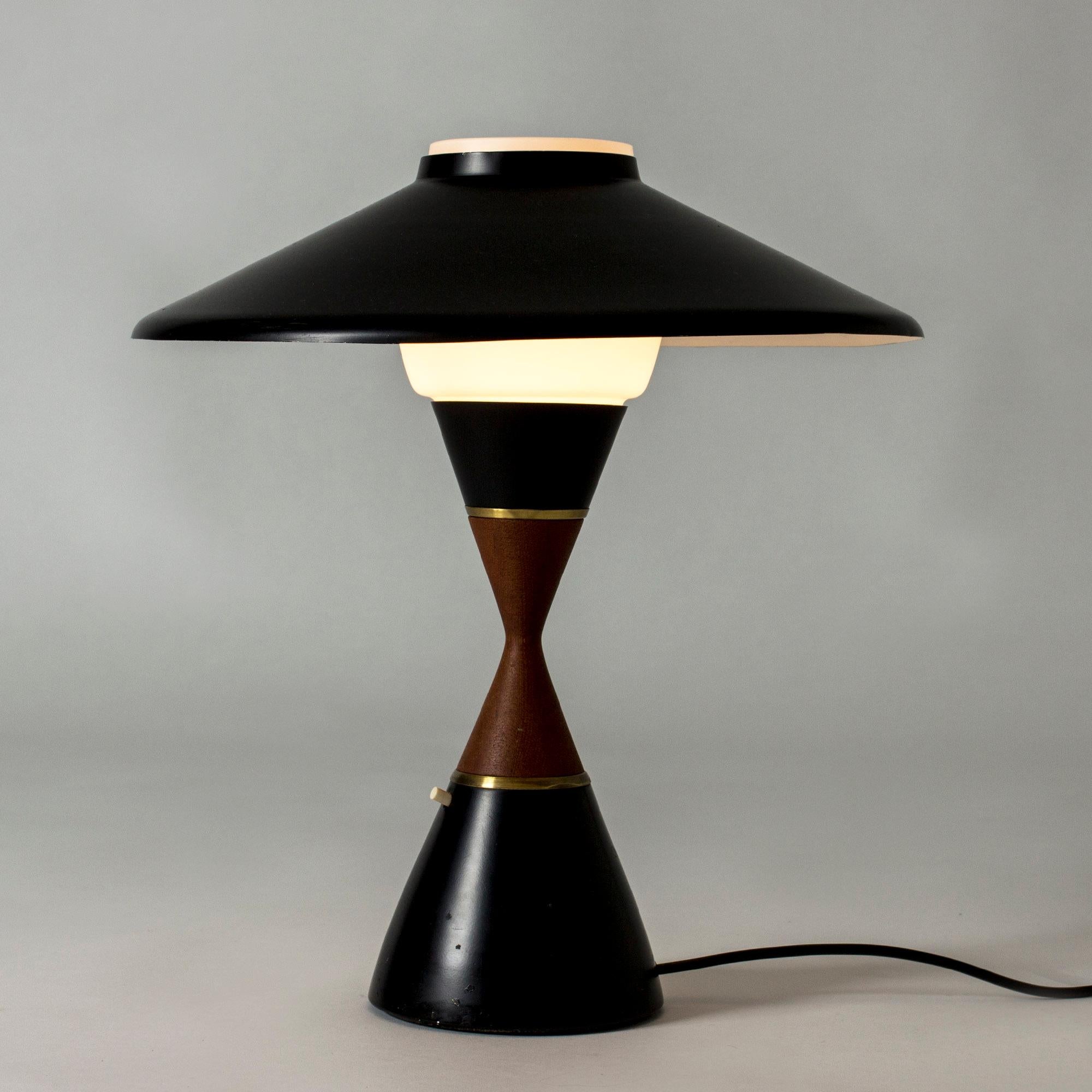 Table lamp in a cool design with graphic lines by Svend Aage Holm Sørensen. Black lacquered metal and teak waist.