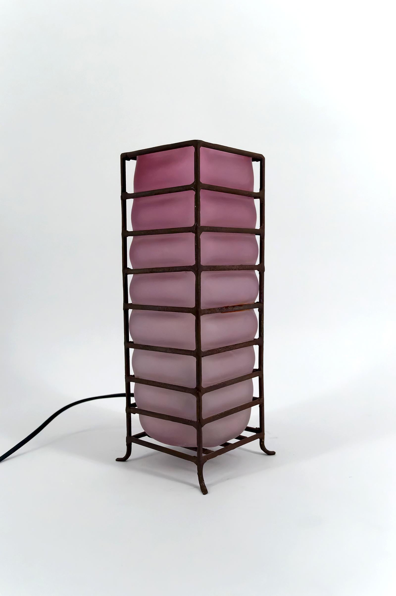 Nous vous proposons cette élégante lampe de table, datée des années 1950-1960, parfait exemple du design moderniste de l'époque. 
Idéale pour apporter une touche de sophistication à votre intérieur, cette lampe se distingue par une structure en fer