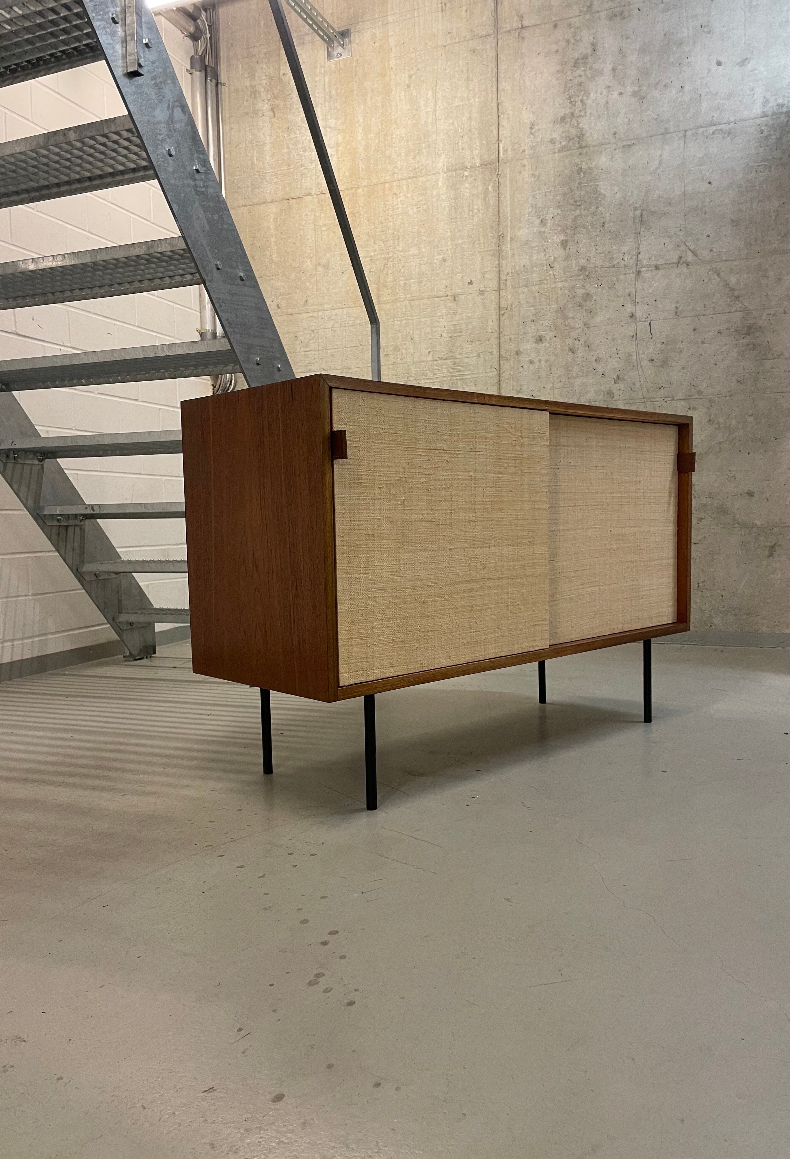 Ein klassisches modernistisches Design-Sideboard von Florence Knoll, Modell 116 für Knoll International - diese Version wurde 1968 von Knoll International in Stuttgart hergestellt. 

Er verfügt über die typischen Schiebetüren mit Seegras, die auch