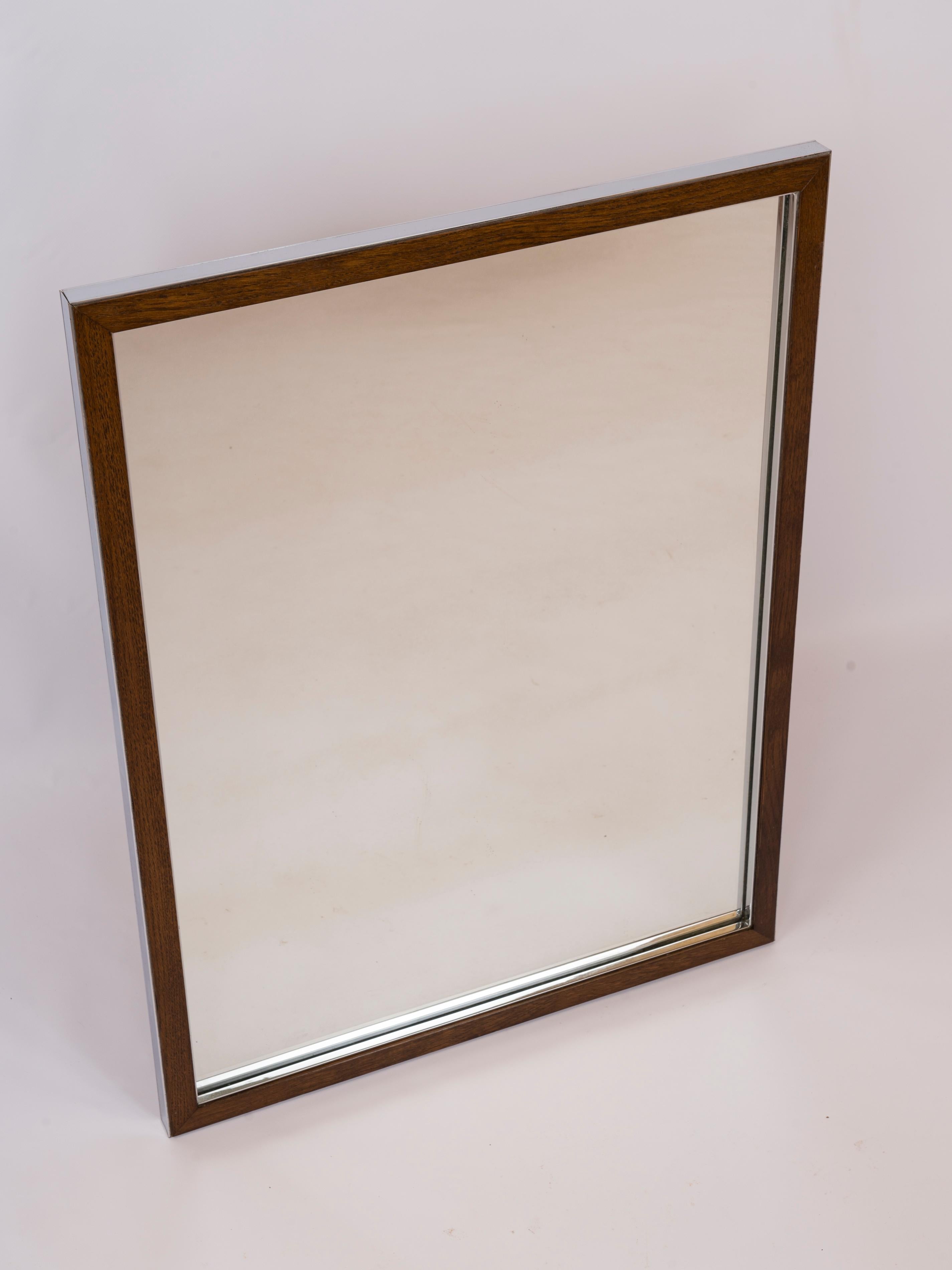 Sleek modernist mirror made of a teakwood frame embedded into a chrome structure. 
Italy 1970's.
In good vintage condition.
This mirror will ship from France and can be returned to either France or to a LIC NY location.
Price does not include