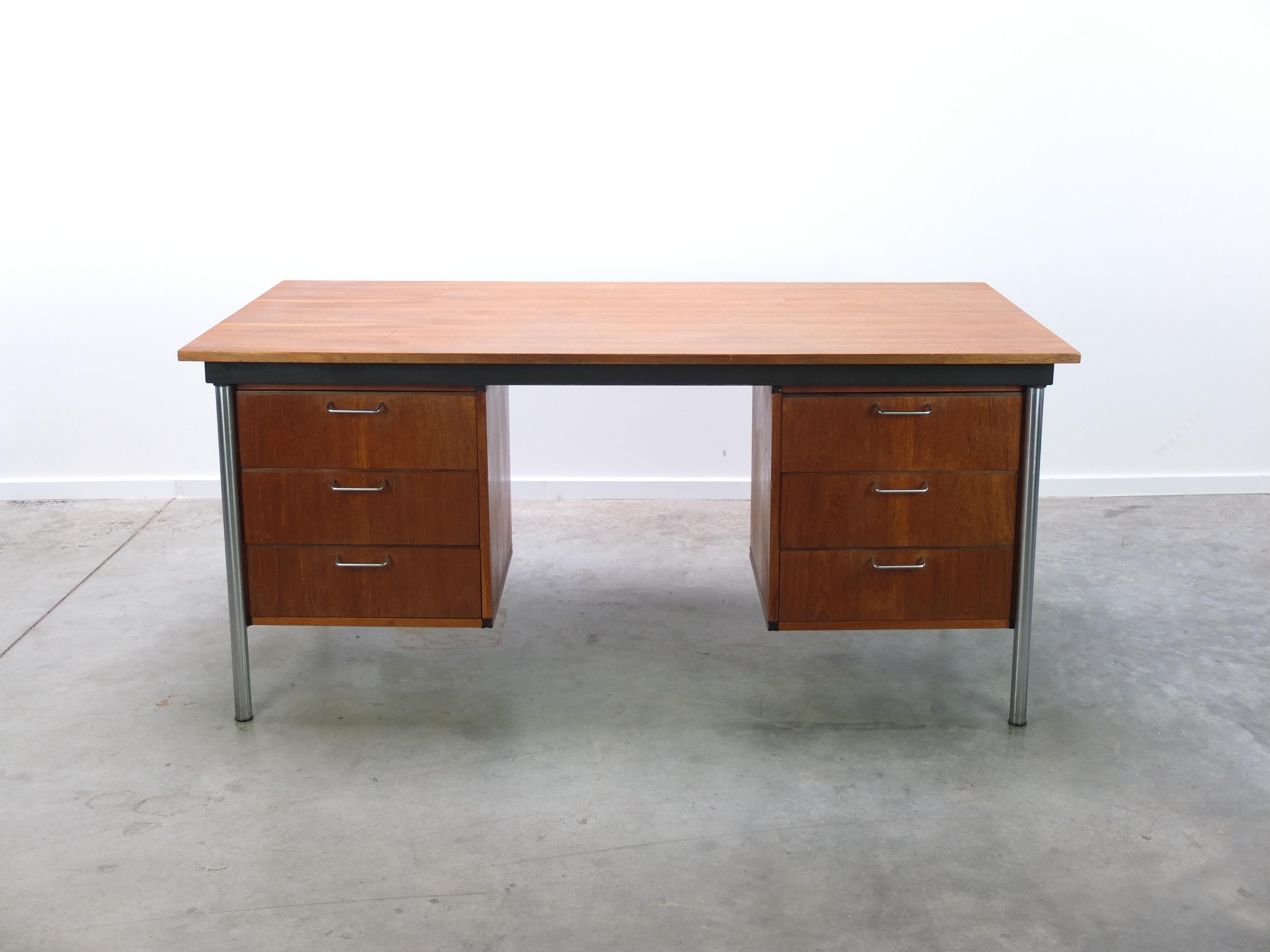 Executive desk designed by Cees Braakman for Pastoe during the 1960s. This model is part of the Made to Measure series recognized by the use of teak wood combined with rosewood joints in the corners. Nice modernist touch thanks to the brushed steel
