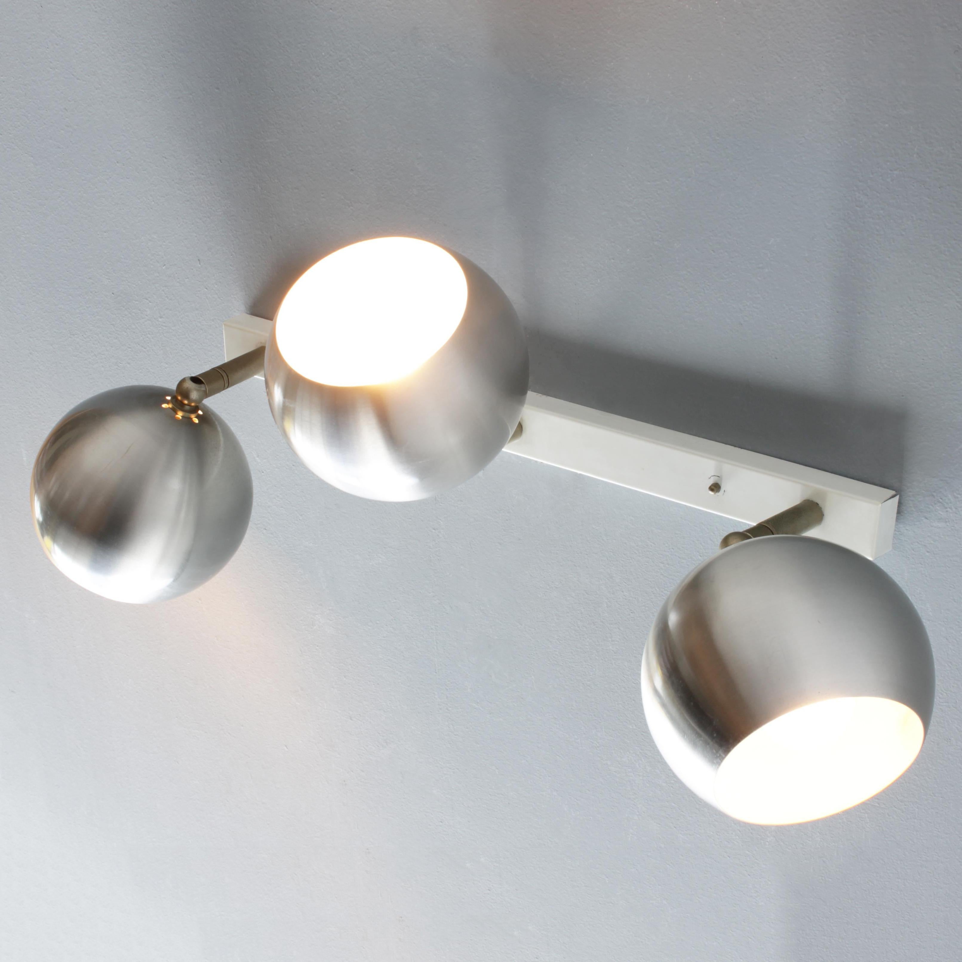 Dutch modernist three light wall or ceiling fixture by RAAK. Period 1960-65. Three spotlights in brushed aluminum and nickel on a lacquered metal rail. Marked with a label.
The fixture is equipped with the original, regular (E26-E27) Edison screw