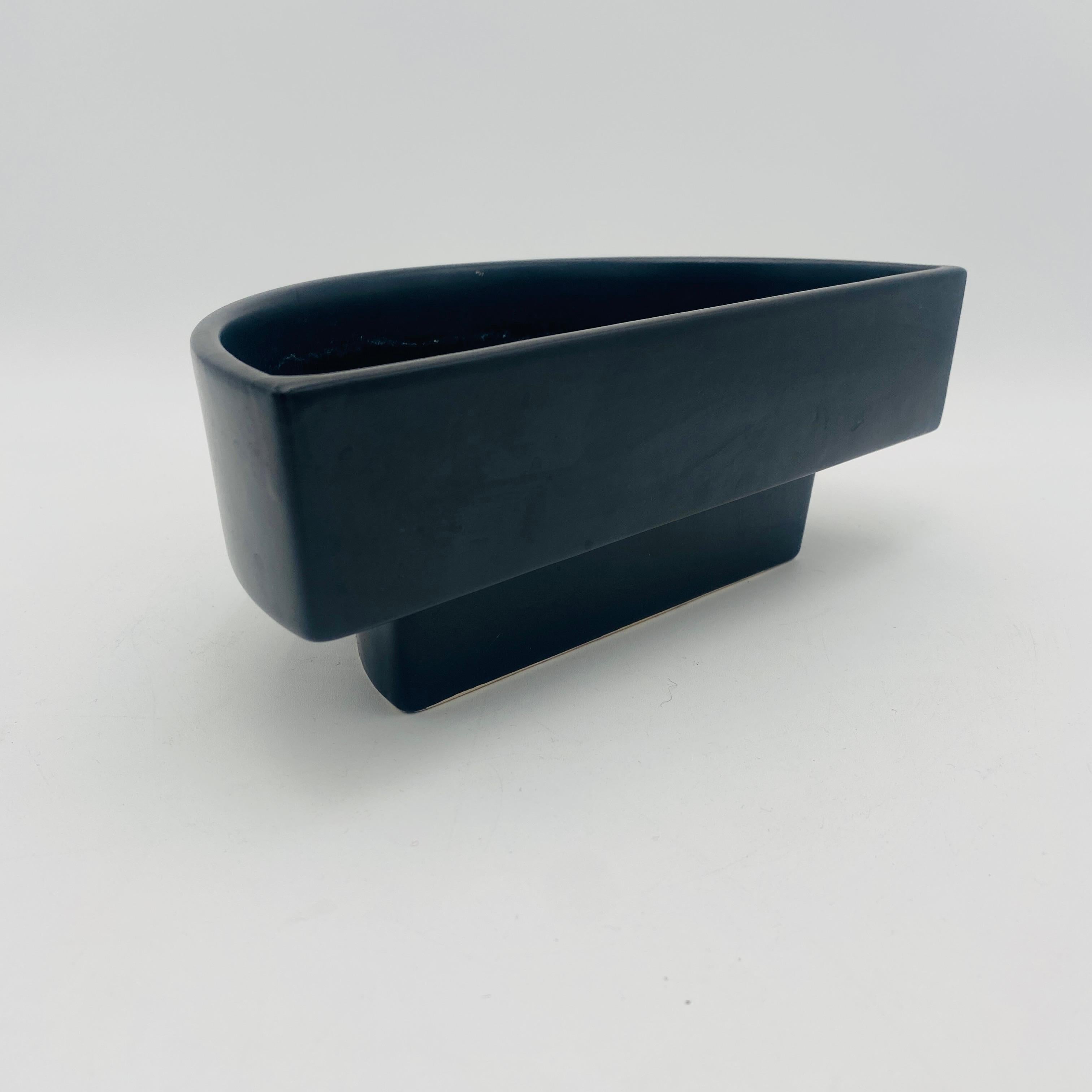 Questa fioriera ikebana in ceramica giapponese di metà secolo emana un'eleganza senza tempo e una moderna raffinatezza. Caratterizzata da un'elegante finitura scura e opaca, questa fioriera a forma di mezza luna è ideale per mettere in mostra i tuoi