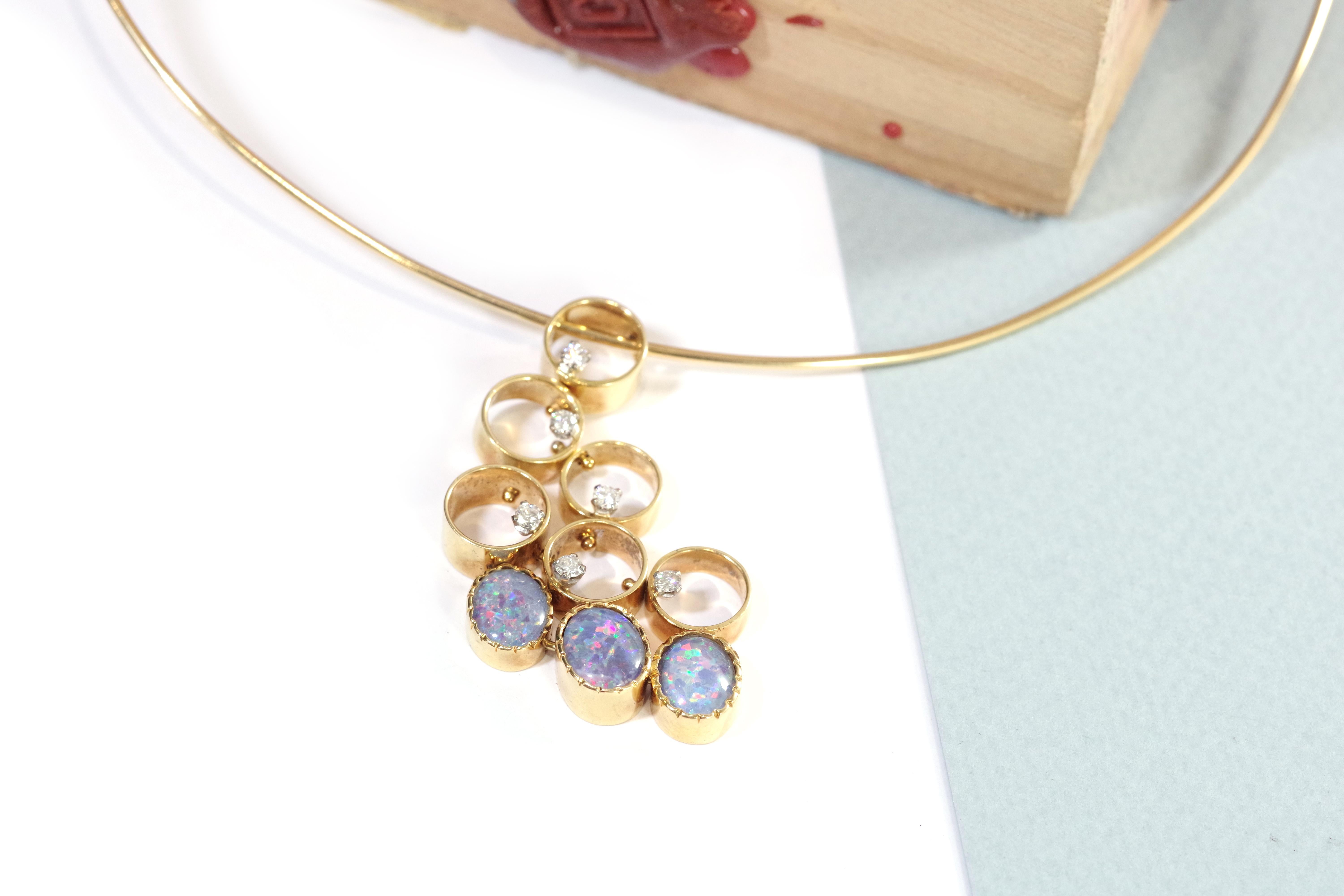 Modernist triplets opals diamond necklace in 18-karat yellow gold (750 thousandths). Original necklace formed by a rigid hoop holding a pendant composed of articulated circular gold elements, adorned with six brilliant-cut diamonds, and three oval