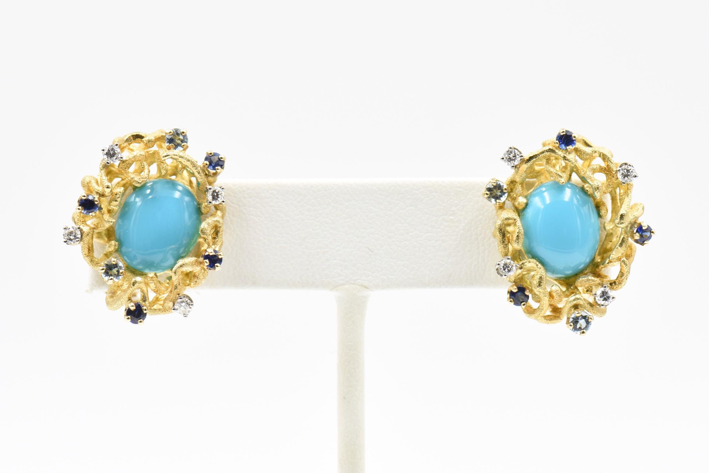 Wonderful 1960's earrings by Jack Gutschneider have a turquoise cabochon mounted in a freeform 14k gold nest with sapphires, diamonds and blue topaz prong set in the gold.   The earrings are clips with posts.  Earrings are 1