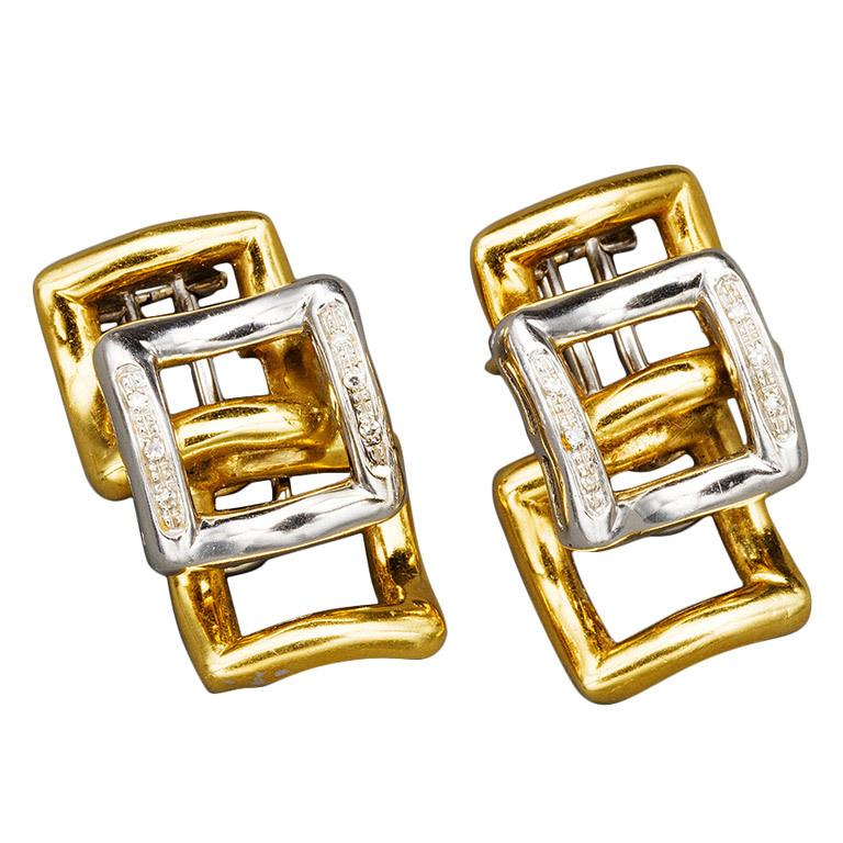 Beautiful Modernist pair of earrings of geometric design each featuring a curved open 18k white gold square set on two sides with small diamonds applied to two overlapping curved open 18k yellow gold squares, mounted as clips. 

Italy, 1970s

1 x
