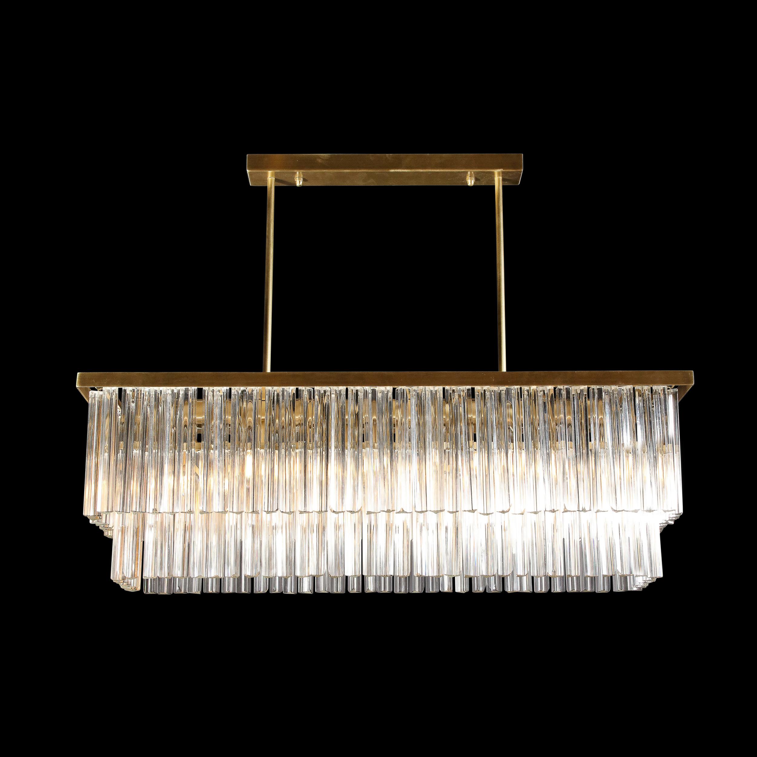 This stunning and dramatic modernist triedre chandelier was realized in Murano, Italy- the island off the coast of Venice renowned for centuries for its superlative glass production. It features two tiers of Murano triedre crystals- one of the most