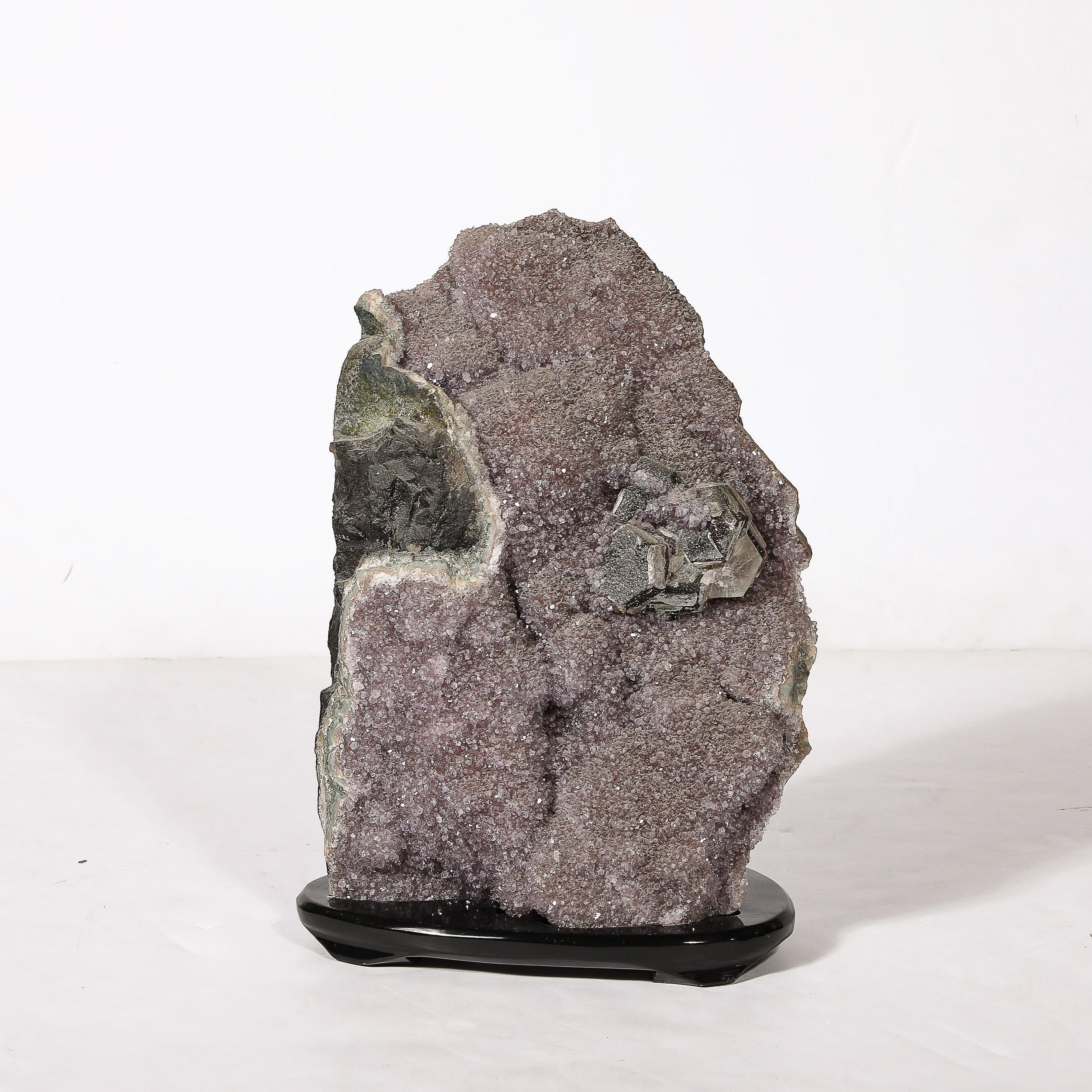 This powerfully scaled and stunning Modernist Uruguayan Amethyst Rock Crystal Specimen on Black Lacquered Base originates from Uruguay during the latter half of the 20th Century. Features an incredible specimen of Amethyst hued rock crystal,