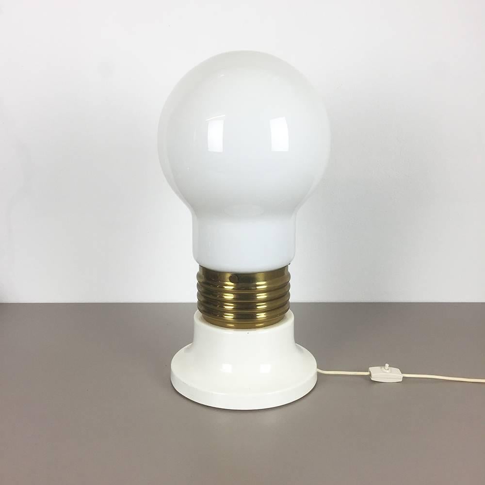 Giant bulb light,

origin Italy,

1970s.

Original 1970s giant glass bulb table light. The base and middle of this light are made of solid metal, the base is lacquered is white, the middle part has a brass tone finish. The huge glass shade is