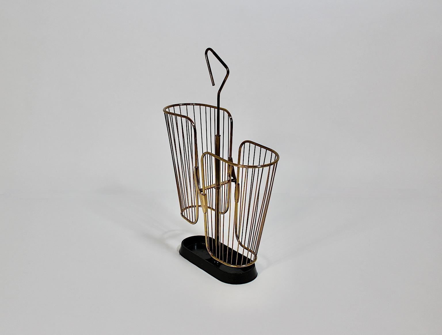 Modernist Mid Century Modern Vintage umbrella stand from brass, aluminum and black lacquered metal 1950s Germany.
A beautiful vintage umbrella stand showing a brass cage and black lacquered metal base.
This umbrella stand features a brass cage body