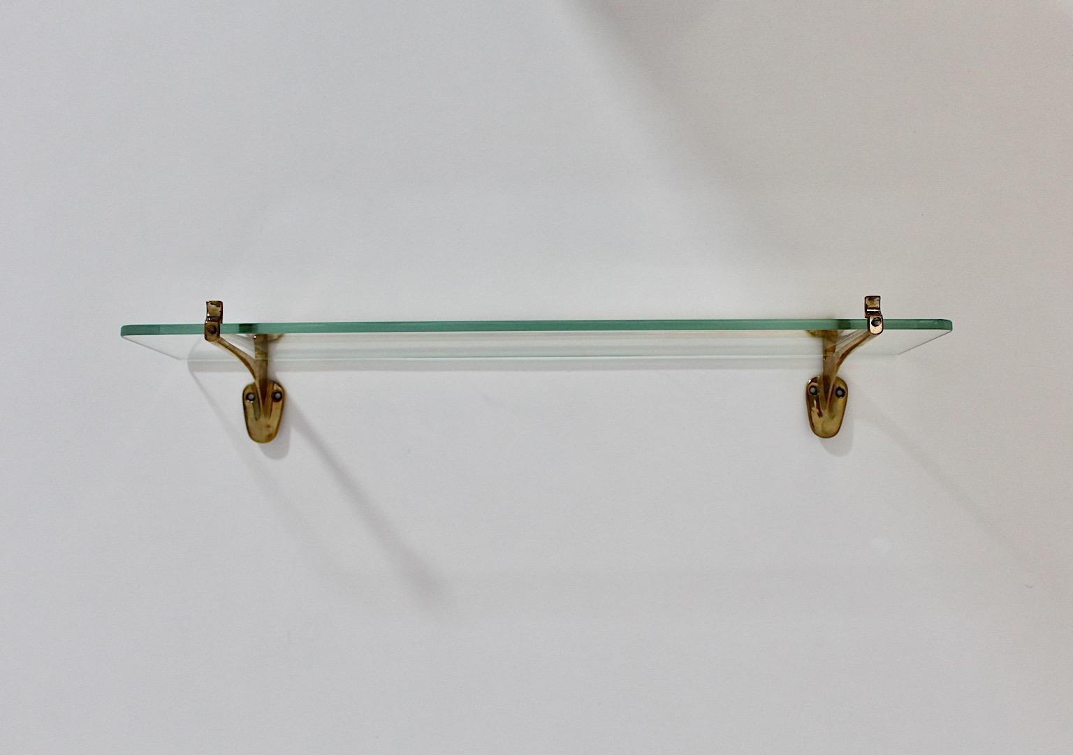 Modernist vintage shelf from solid brass and clear thick glass 1950s Italy.
A beautiful wall shelf from solid brass and thick glass designed and manufactured 1950s Italy.
This wall shelf features amazing brass details and a thick glass shelf. The