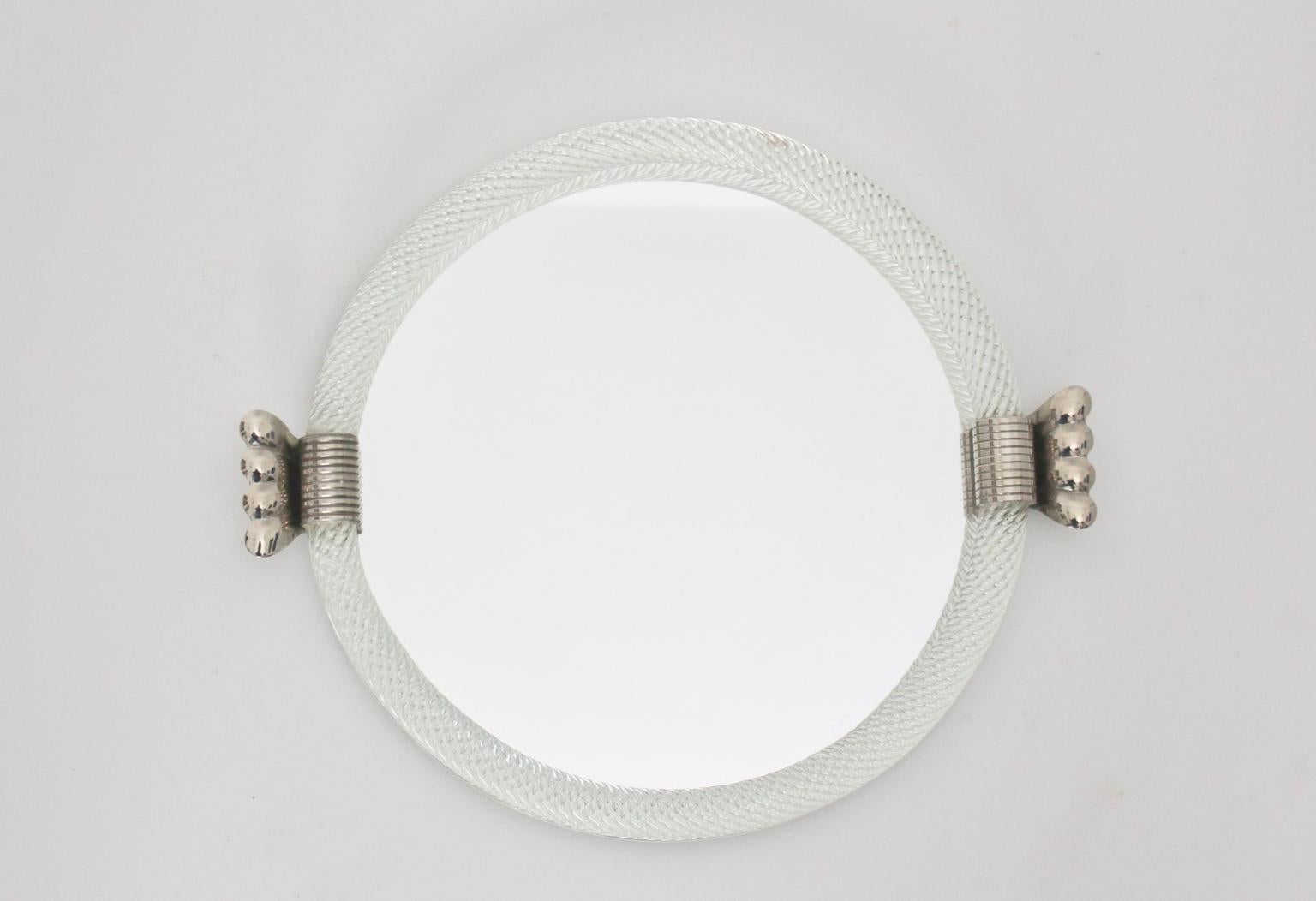 The modernist vintage glass mirror tray by Barovier & Toso attributed, Italy, shows a colorless glass frame with two nickel-plated handles on each side. Furthermore the mirror features mirror glass and fibreboard.
The vintage condition is very