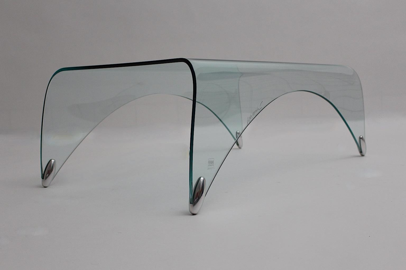 Modern Vintage organic waterfall sofa table or coffee table model Genio from clear security glass with metal details by Massimo Iosa Ghini for FIAM Italy, end of 20th century.
This wonderful sofa table shows slightly rounded shape from clear