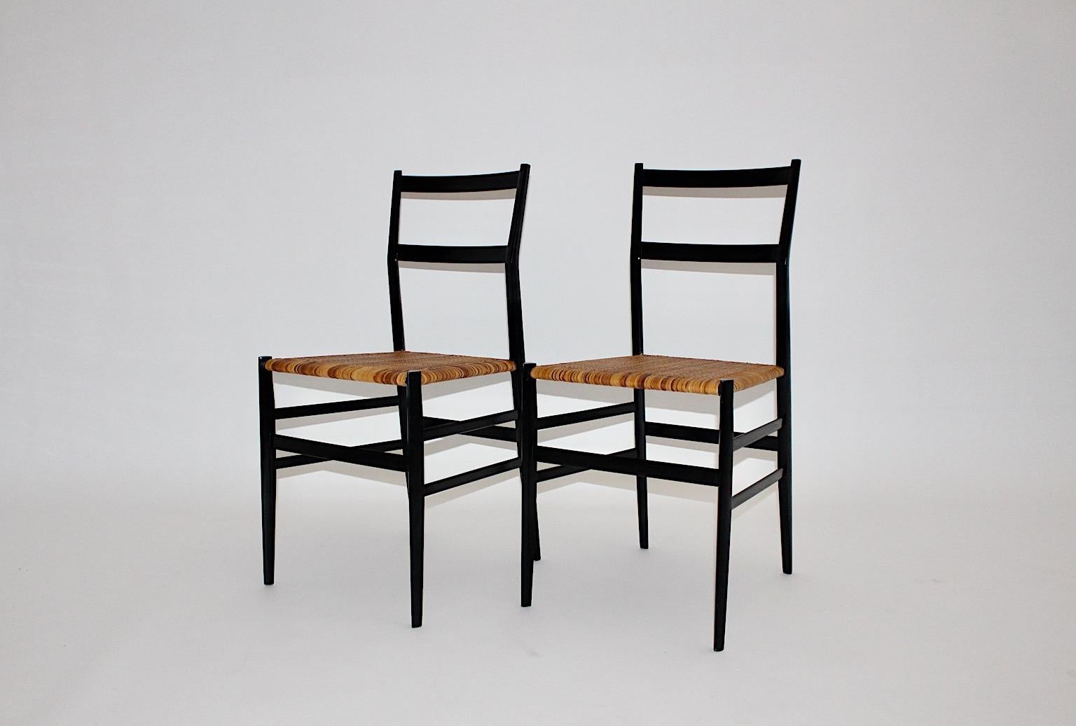 Modernist Vintage authentic pair or duo Superleggera Dining Chairs or Chairs from black lacquered wood and light brown cane mesh designed 1957 by Gio Ponti and manufactured 1980s for Cassina.
This elegant duo from dining chairs or chairs features a