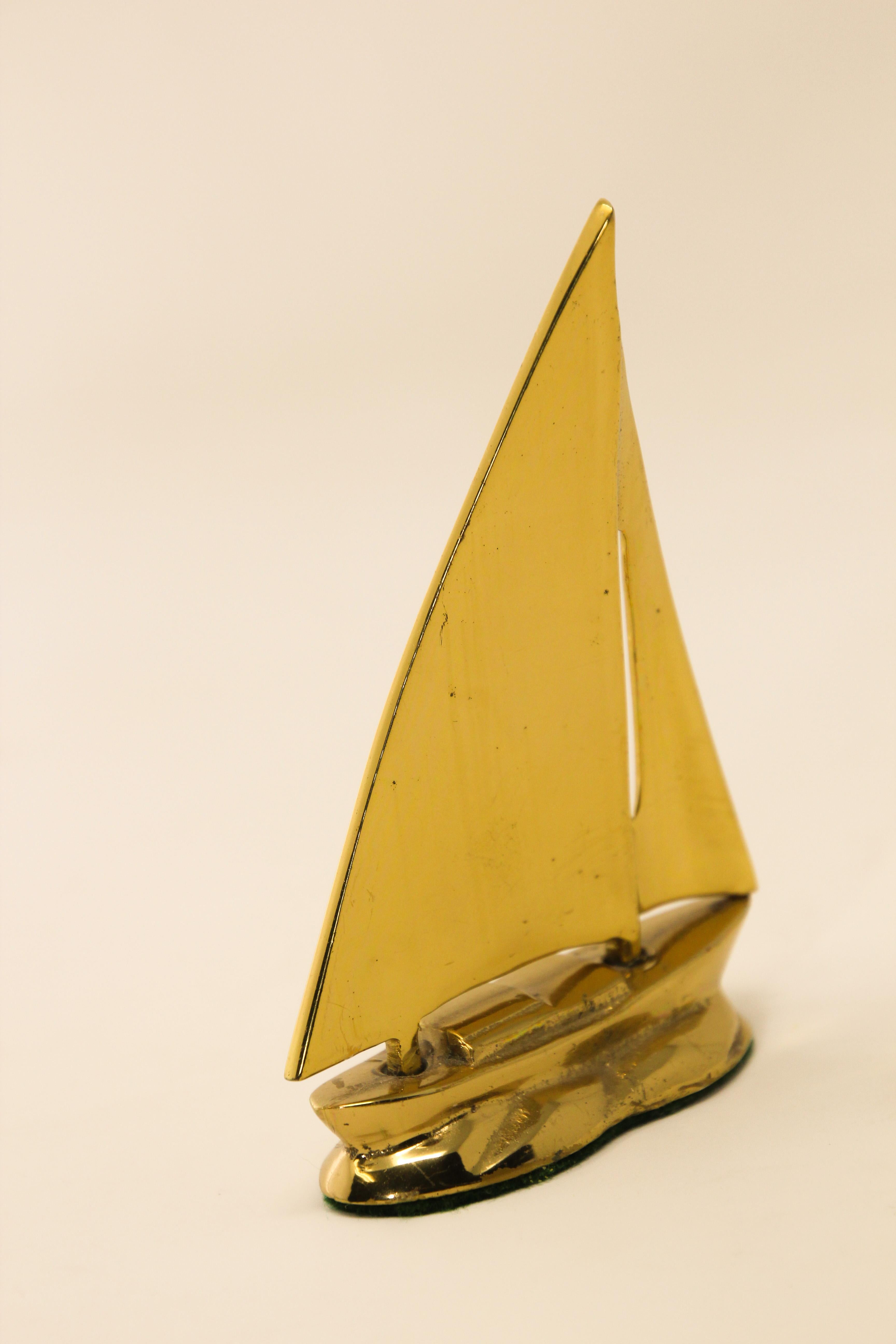 Modernist small polished brass sailboat paperweight.
A sturdy and sleek midcentury brass sailboat.
Vintage beautiful midcentury figural solid brass sailboat, figurine would be perfect for adding a touch of nautical flair to a coffee table, bookcase,