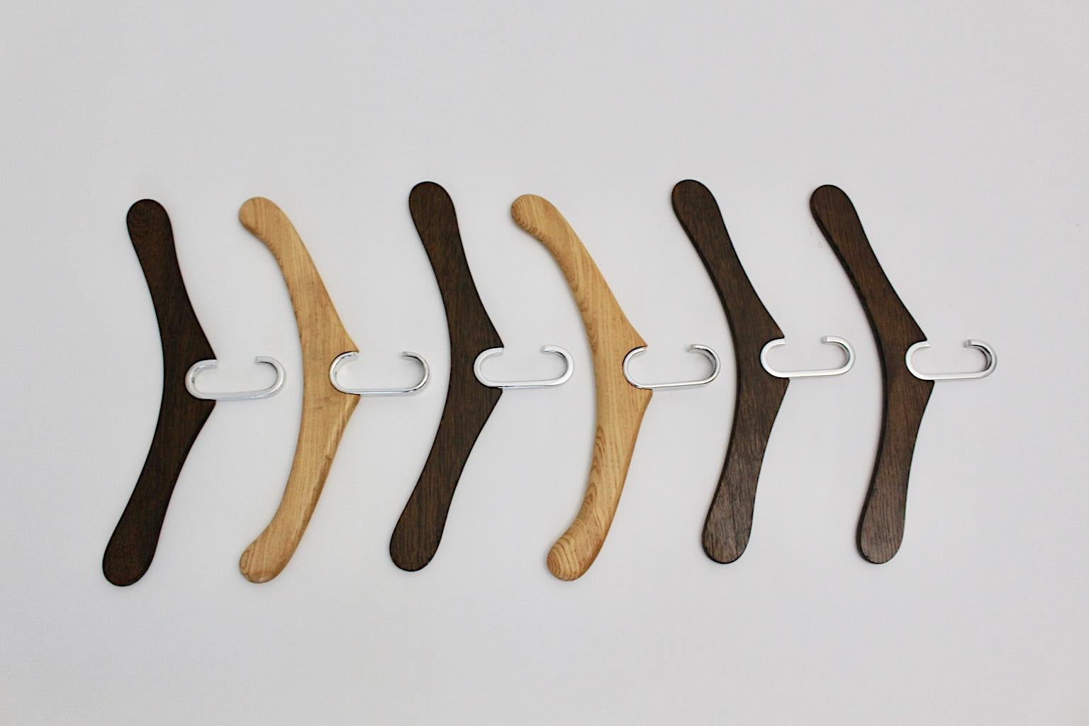 A set of six modernist vintage oak cloth hangers, which were designed and made in Austria, circa 1970.
Two pieces were made out of colorless lacquered oakwood and four pieces were made out of brown stained oakwood. All six pieces show an aluminum C