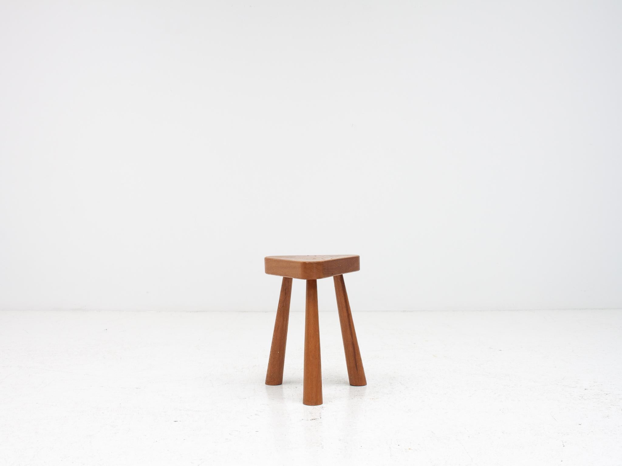 A modernist mid-century vintage stool.  Sitting on three tapered legs and formed of elm.

Reputed to have been made in 1977 in Salisbury Cathedral workshops from 