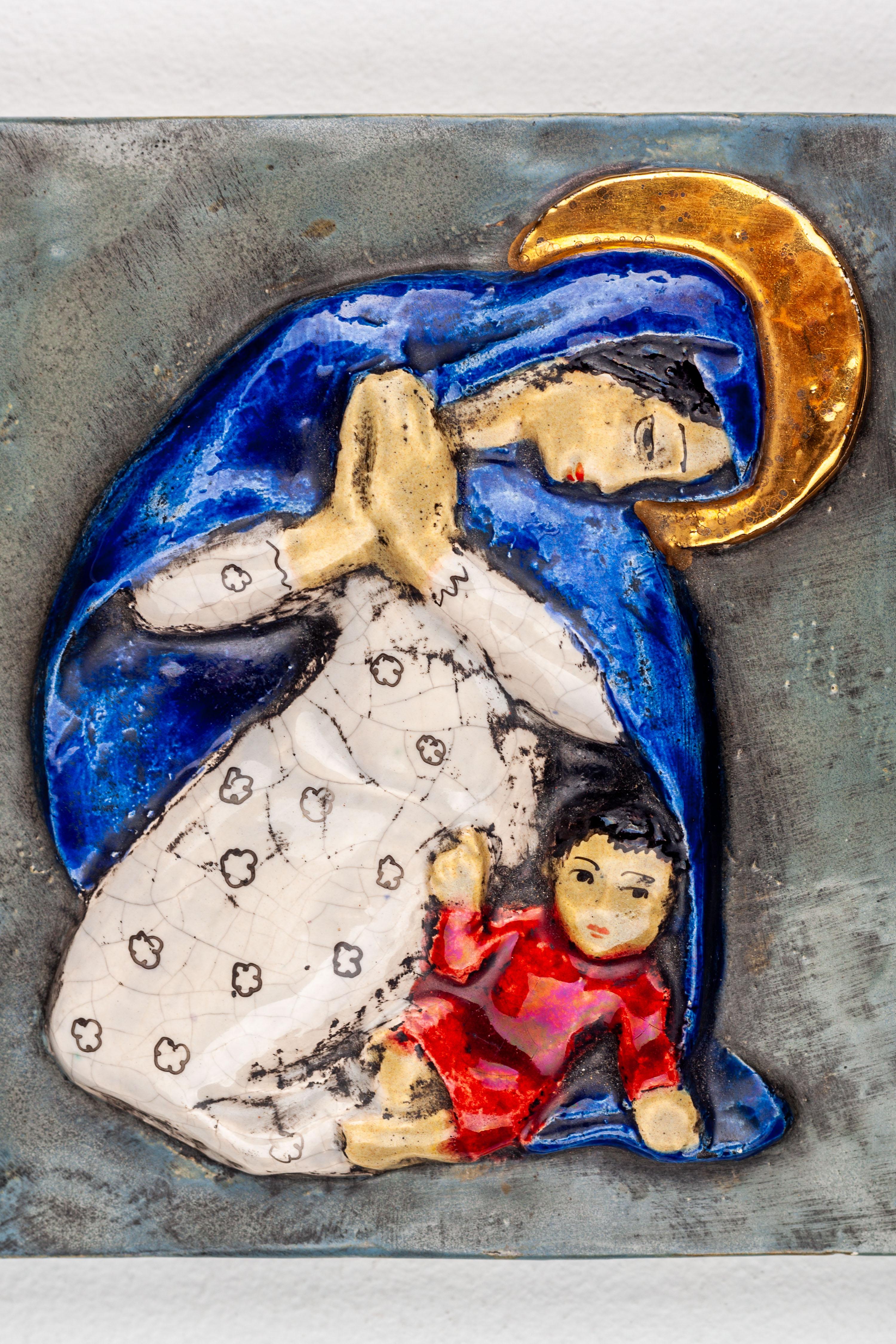 Virgin Mary and Child Jesus Wall Ceramic Decoration handmade by Modernist Studio Pottery artist. Virgin Mary with praying hands, wearing a white dress and night blue cape covering her head and shoulders, gold aureola. With playful Child Jesus in red