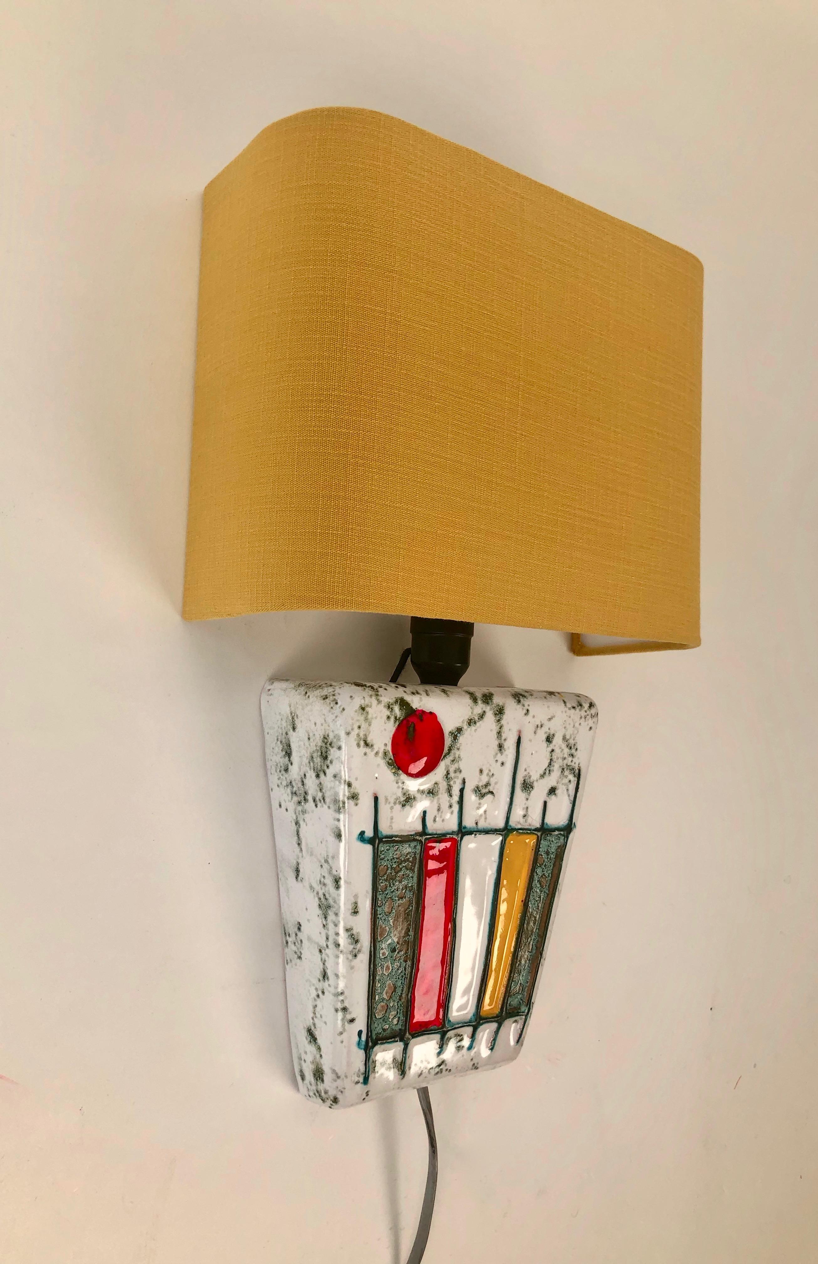 This Modernist ceramic wall light was made during the Studio Ceramics Movement in Hungary, in the 1950's.
The hand formed ceramic element is glazed and the decoration reflects what was happening in painting
at that time.

The new shade is based