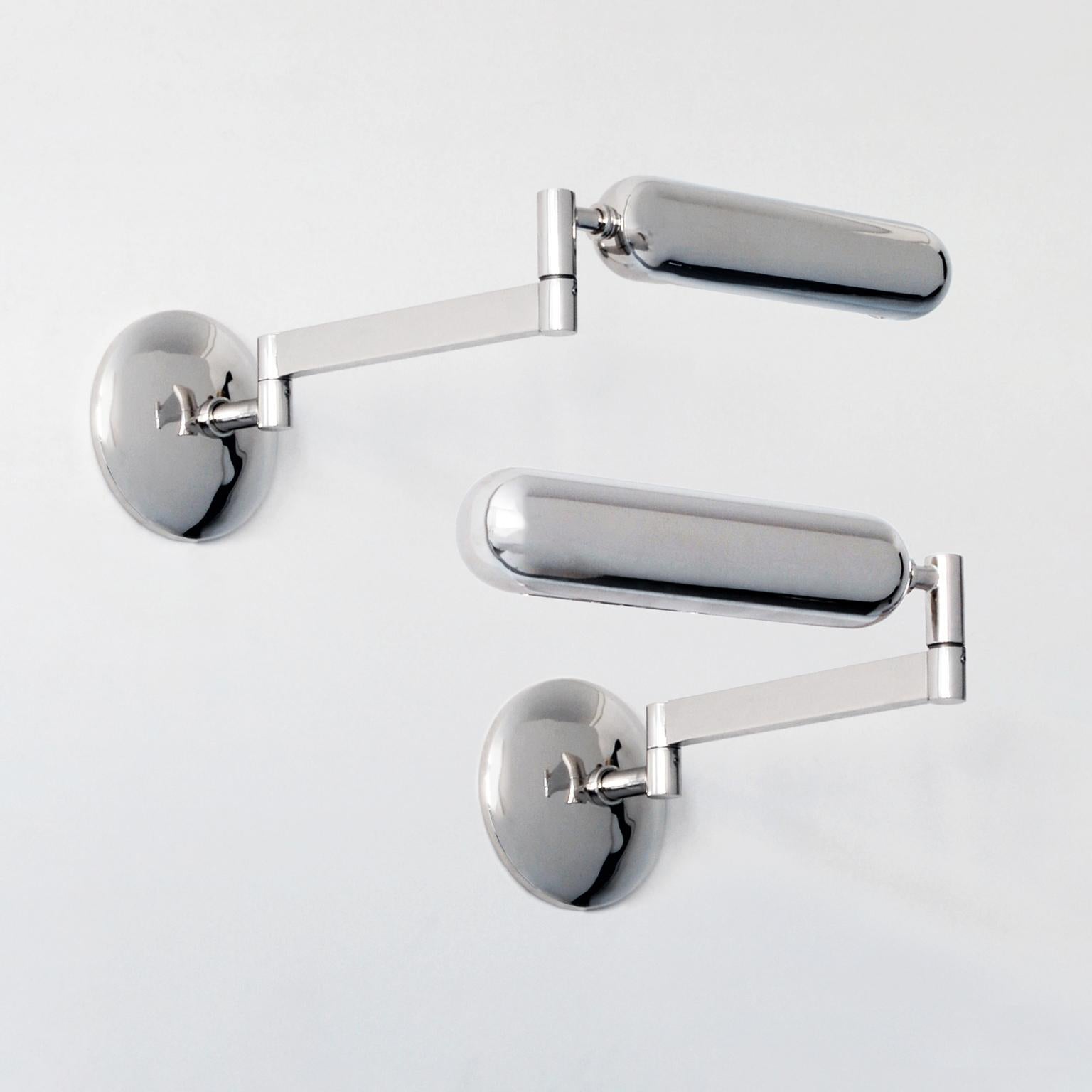 Modernist wall lights with horizontally pivoting support arms and rotating lampshades. The lamp is made of nickel-plated brass.
