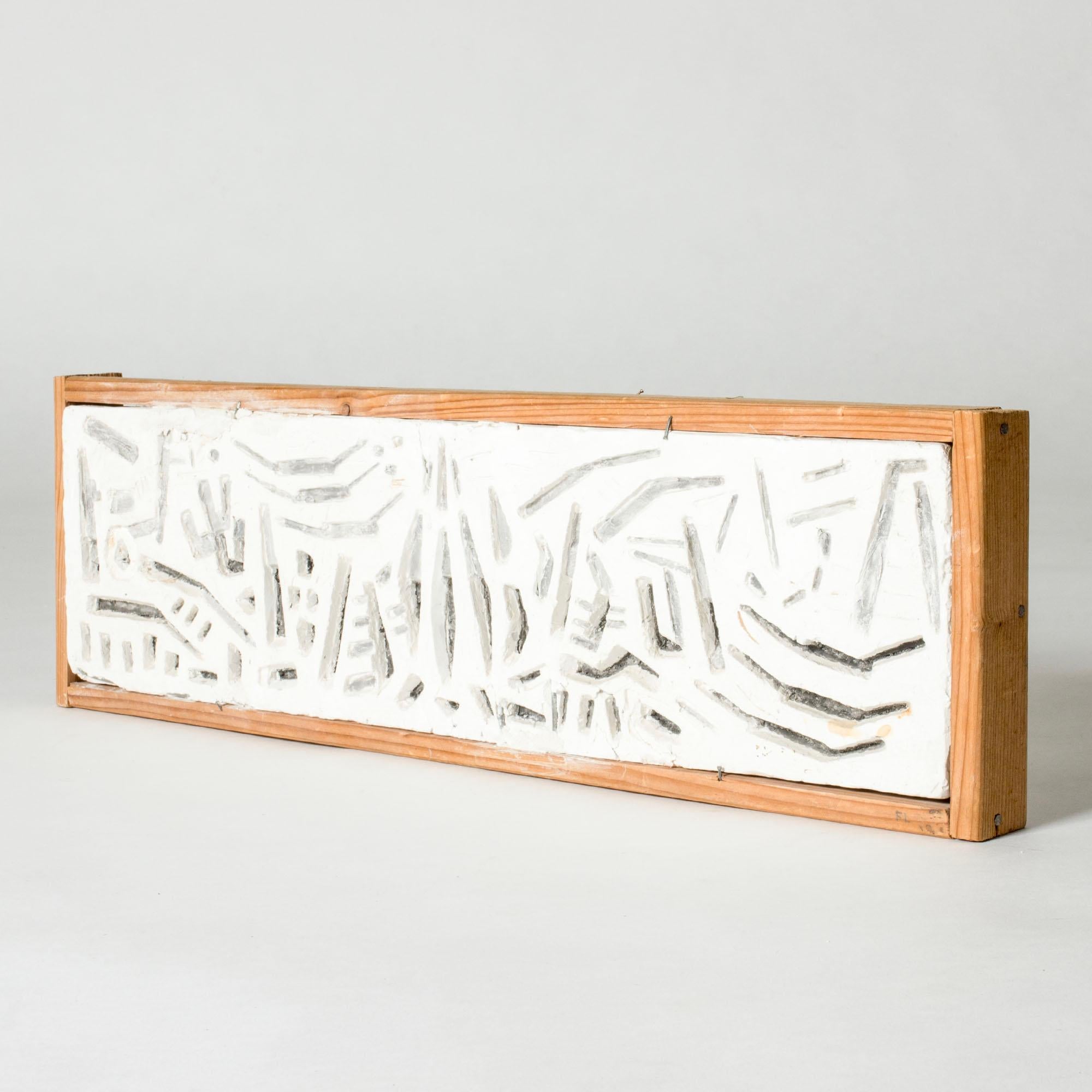 Un sorprendente rilievo da parete di Fred Leyman, con un motivo grafico astratto in gesso. Montato in una cornice di pino rustico.