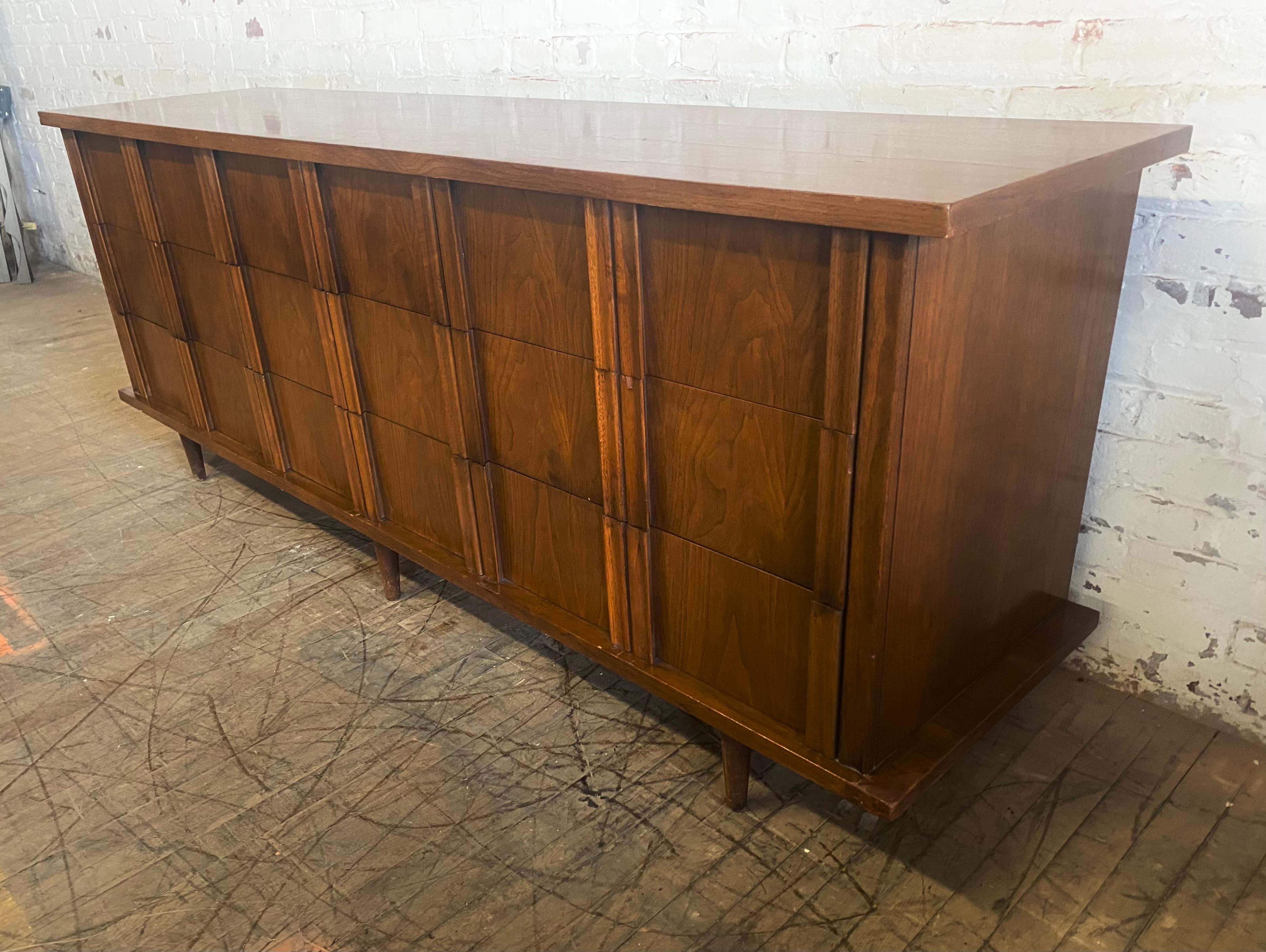 Modernist walnut 9 drawer dresser by American of Martinsville. Great design. Superior quality and construction, generous storage, wonderful figured walnut, book-matched grain. Minor repair to lower front corner (see photo). Hand delivery avail to