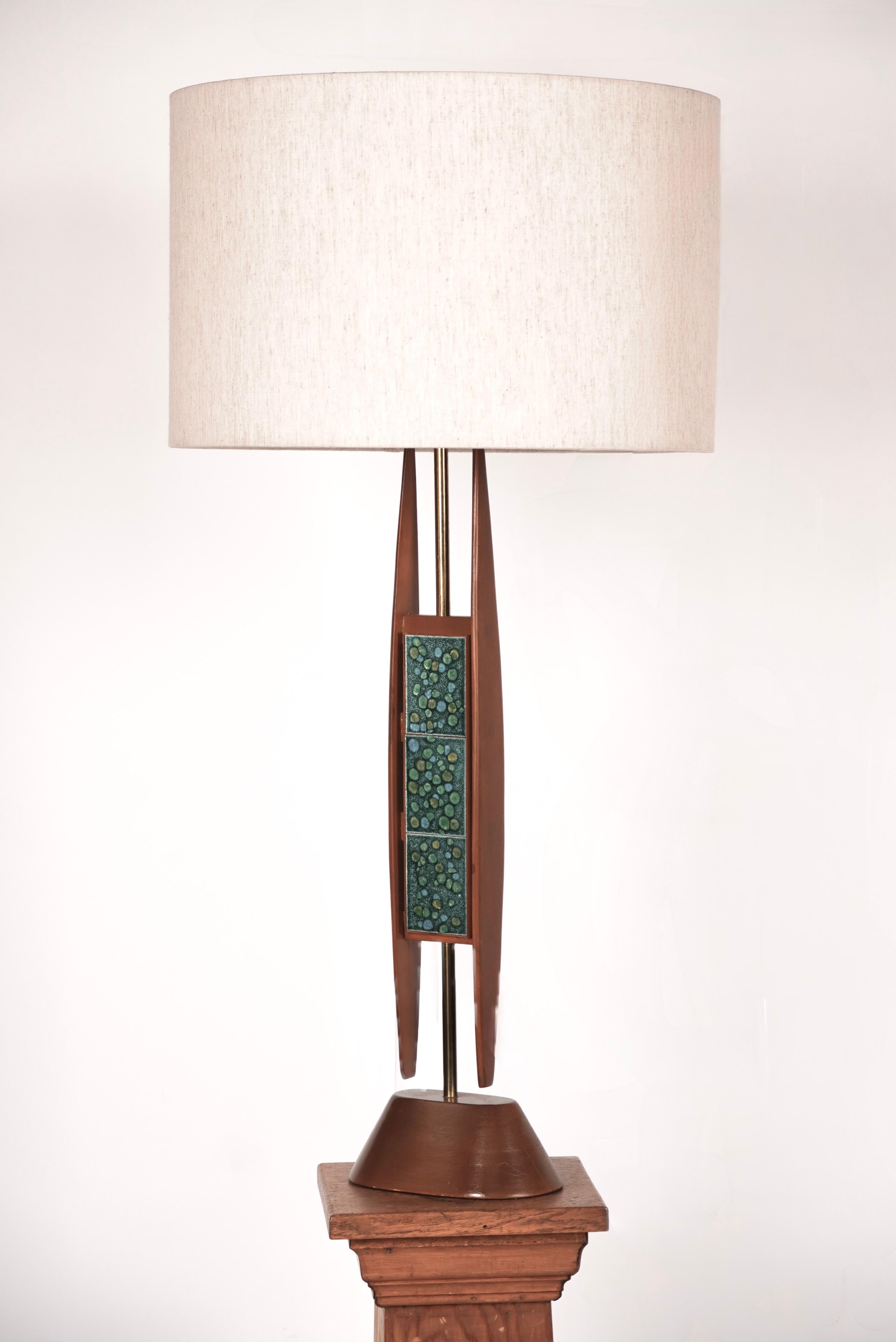 Modernist table lamp in walnut with enameled copper plate embellishments attributed to the Modeline lighting company. Having a rich toned walnut frame with enameled inserts with greens, blues and warm yellows in the color palette. The body of the