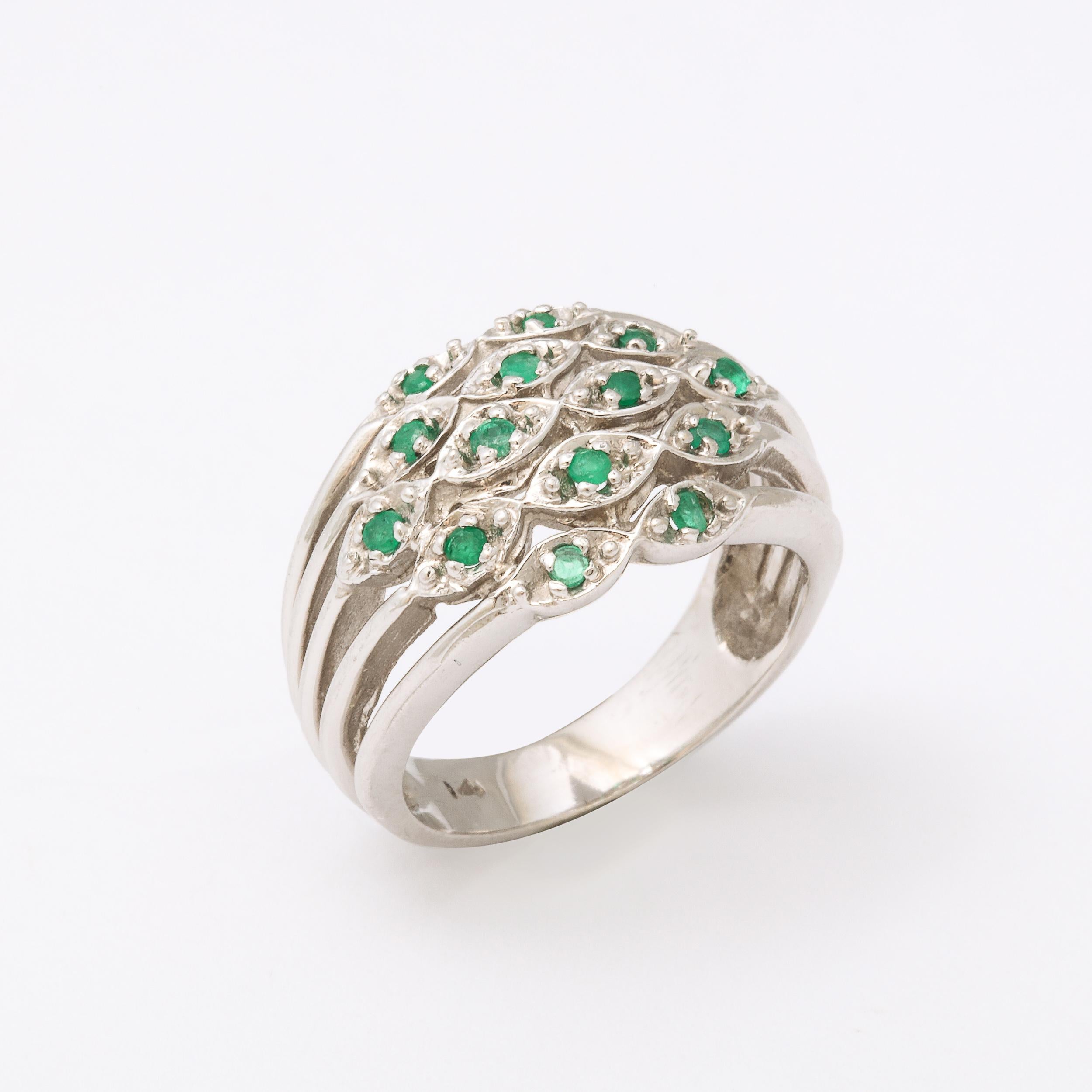 This Modernist 14k white gold ring with a central panel of Lozenge form pendants displaying 14 round cut emeralds.
It is marked 14k  and is a size 8 but buyer can  have it sized to suit. It has a great stylized linear design.  Excellent Vintage
