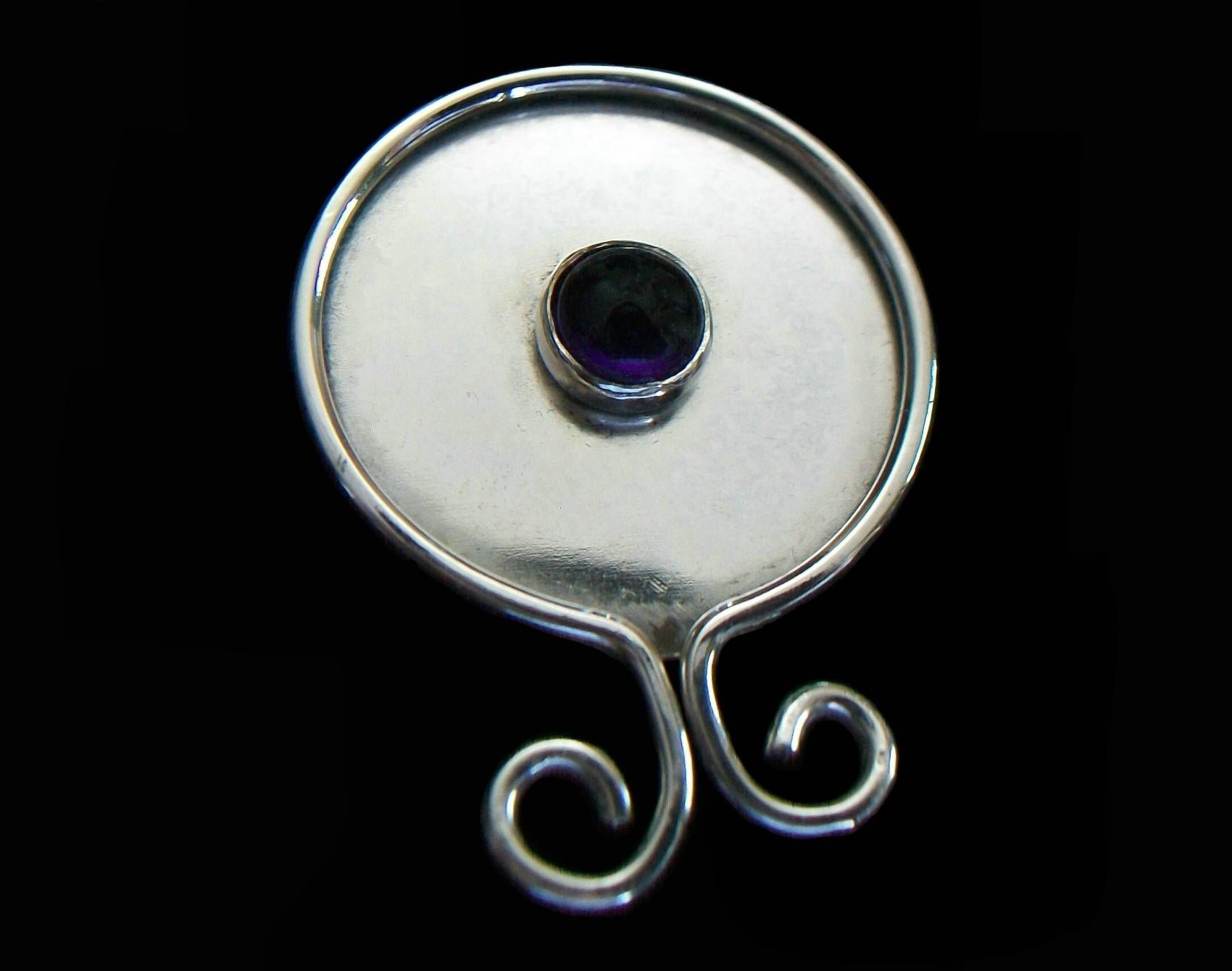 Spilla modernista in metallo bianco e ametista cabochon rotonda - con ametista incastonata al centro (circa 5 mm). Diametro x 3 mm. Profondo = 0,53 carati totali) - il metallo bianco si appanna e non è magnetico - completamente fatto a mano - spilla