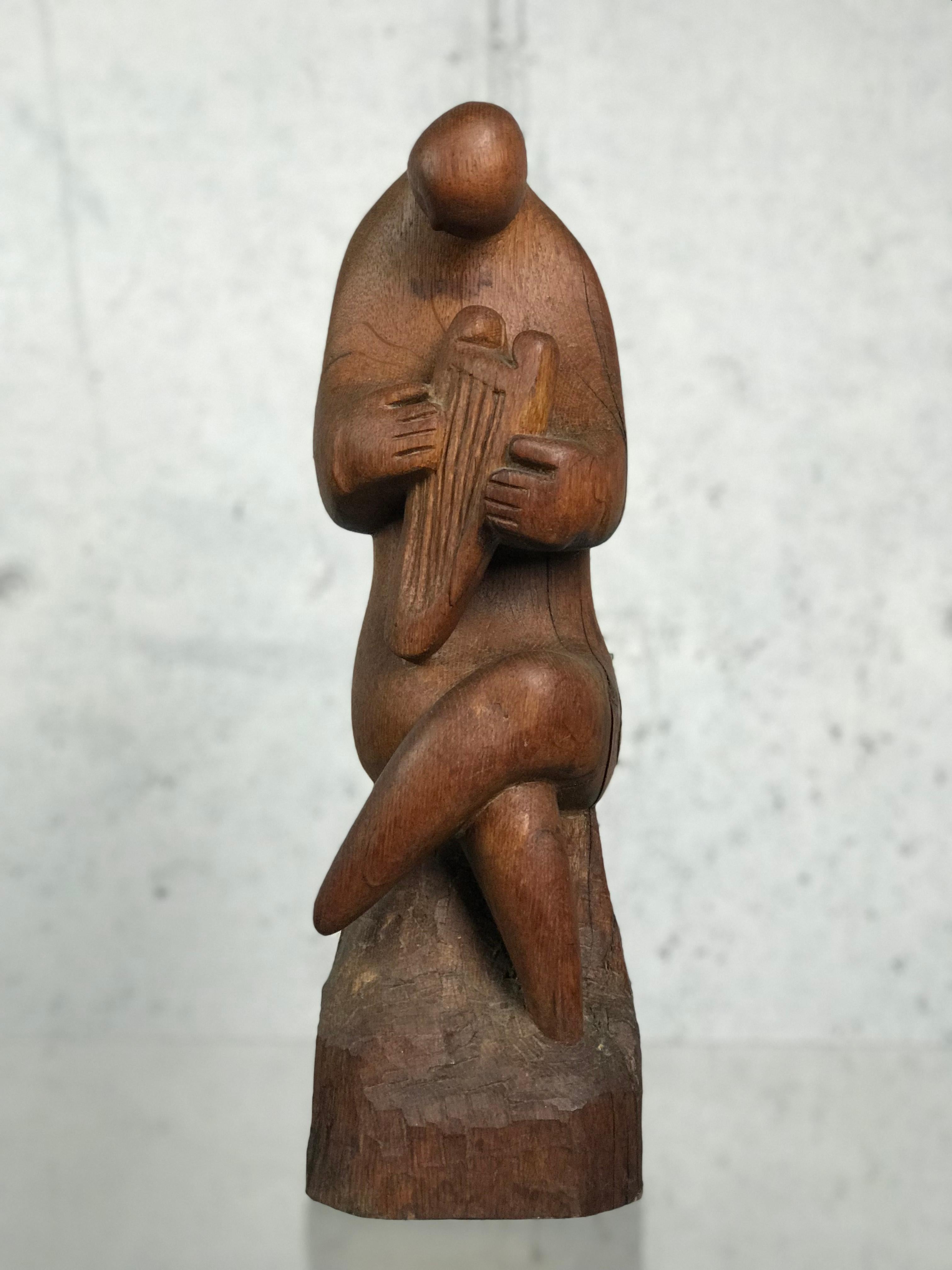 Well executed modernist harp player seated figure carved wood sculpture in untouched condition, circa 1960s. Artist unknown. 16