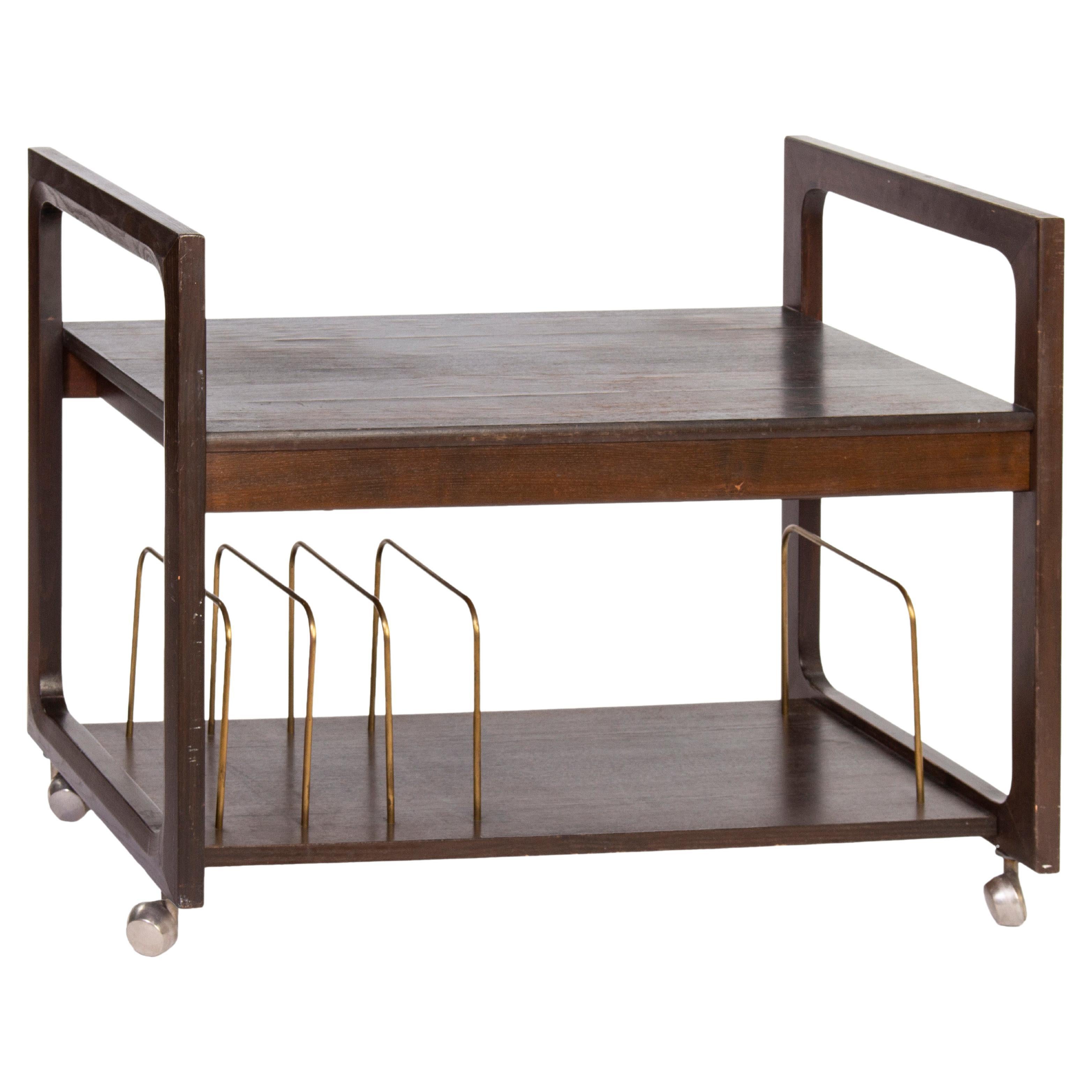 Minimalist Mid-Century Modern bar cart. The wooden structure is complemented with elegant brass guiding placeholders. The two-storey bar cart rolls on four wheels and fits into Classic and contemporary places.
