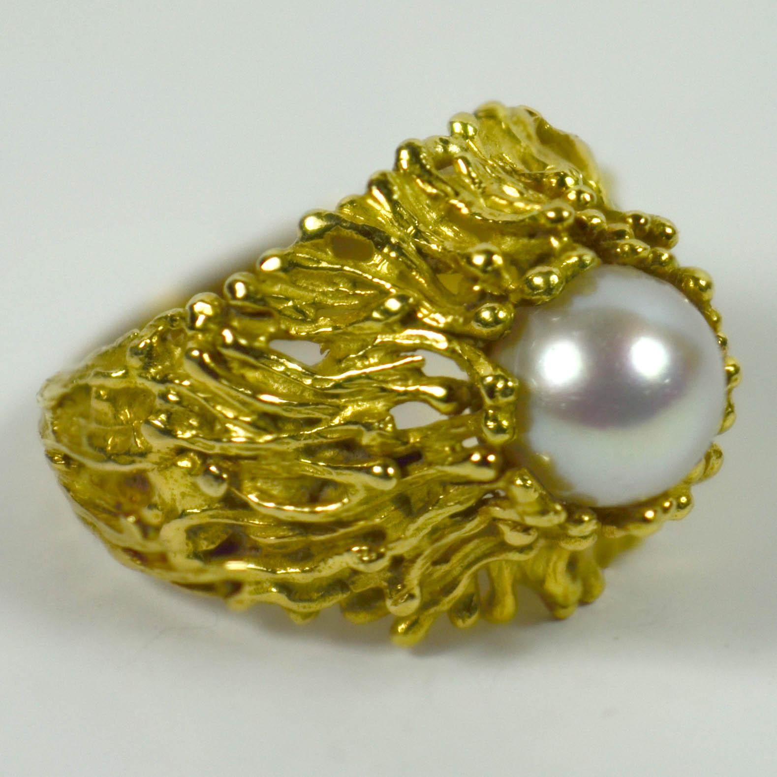 An 18 karat yellow gold ring with organic texture set with a white cultured pearl measuring 8mm in diameter.

Marked Swiss, 18Kt with unknown makers mark.

Ring size 6 (US), L.5 (UK). 

Measurements: 2.8 x 2.1 x 1.8cm. 8.90 grams.