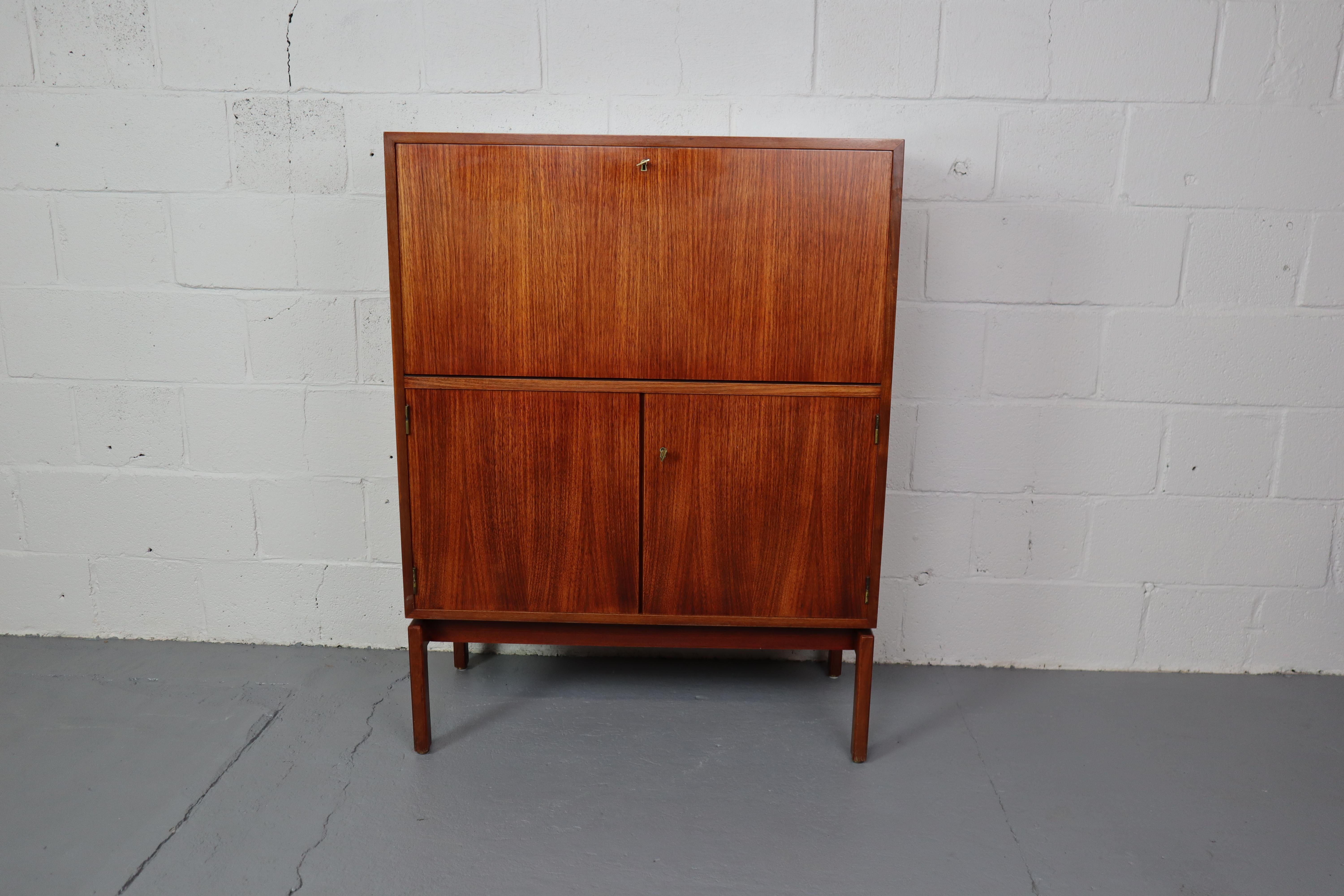 Modernist bar cabinet / secretaire by Jos De Mey for Van den Berghe-Pauvers 1960s.
This cabinet has a drop down door with lighting and 2 doors at the bottom. Top and bottom are equipped with the original brass keys.
114x86x43cm
The cabinet has