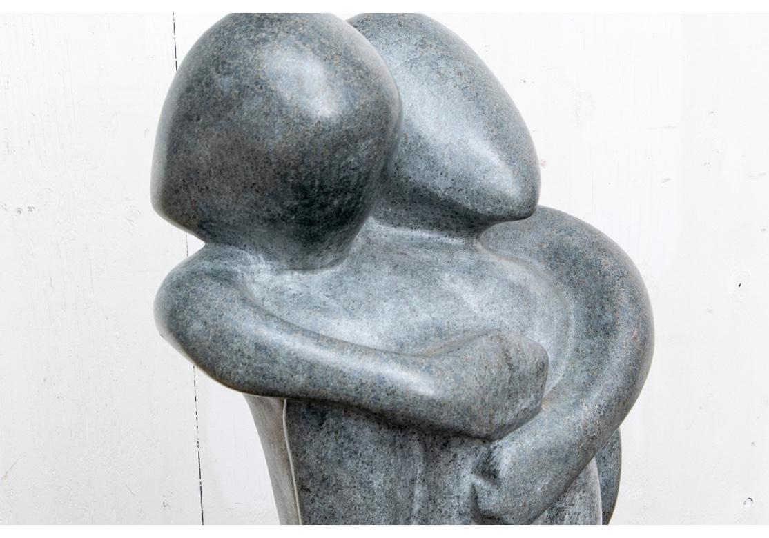 Carved granite sculpture of an embracing couple on a plinth base. Signed on bottom, “SA Tetenbaun 1999” as shown. There is some areas of dirt and slight dirt staining and scratching to the base as the Sculpture was in use in a Garden which does not