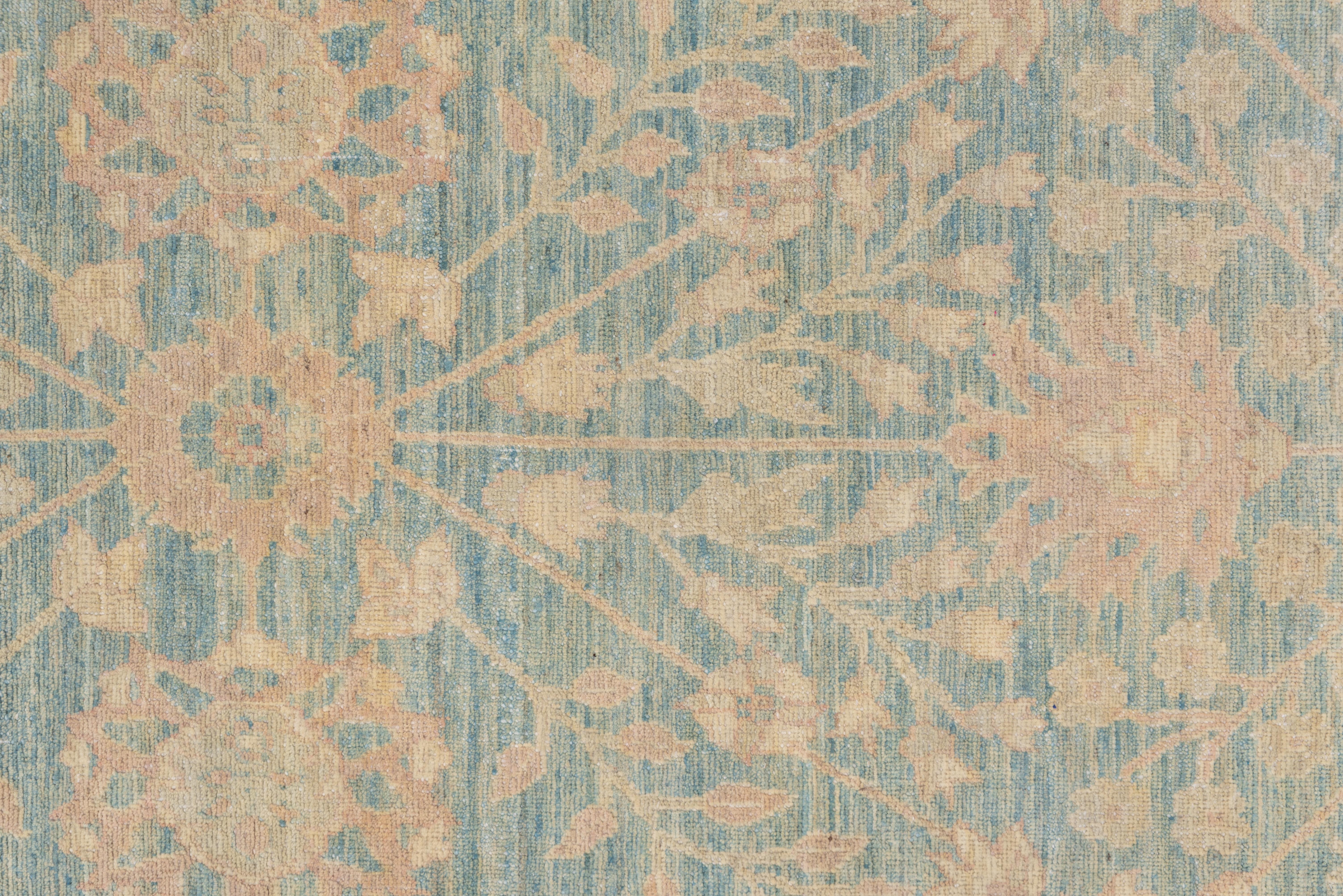 This carpet has a closely patterned all-over rosette and flowering stem layout on an attractively abrashed blue-grey field. The old ivory border shows reversing palmettes separated by oblique, leafy stem segments.
 