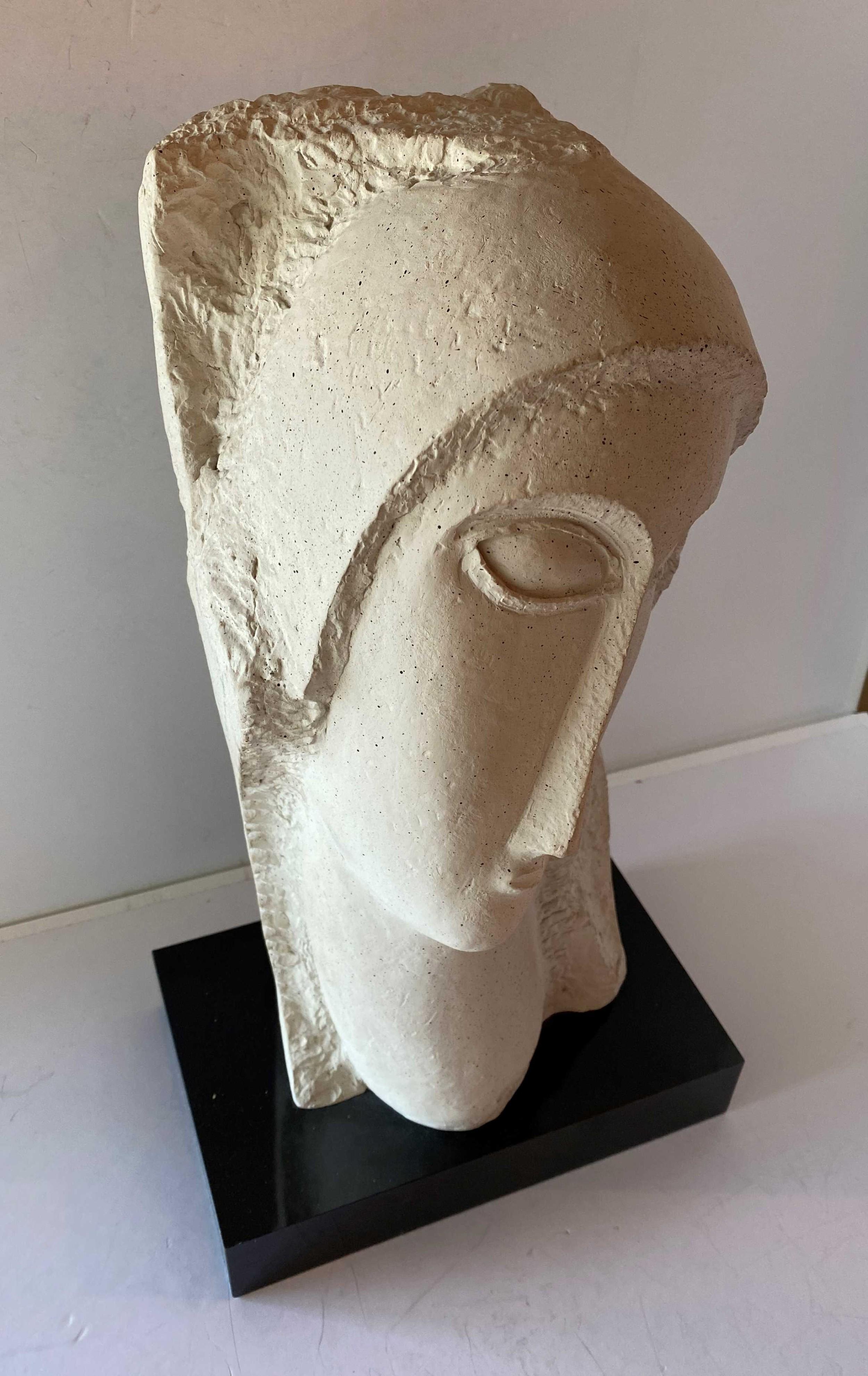 Contemporary Modernist style sculpture of a head made of composite materials resting on a black base (style of Modigiani 