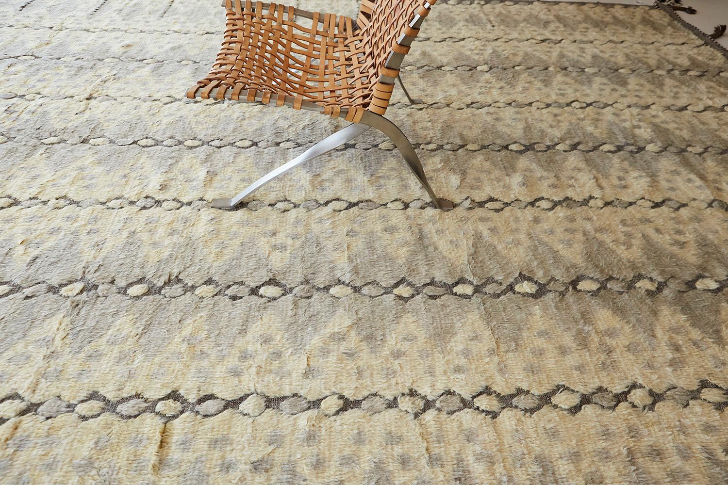 The 'Modlina' rug is a handwoven wool piece inspired by vintage Scandinavian design elements and recreated for the modern design world. The rug's shag balance and harmony, handwoven with a neutral flat weave and unique piles of peach and natural