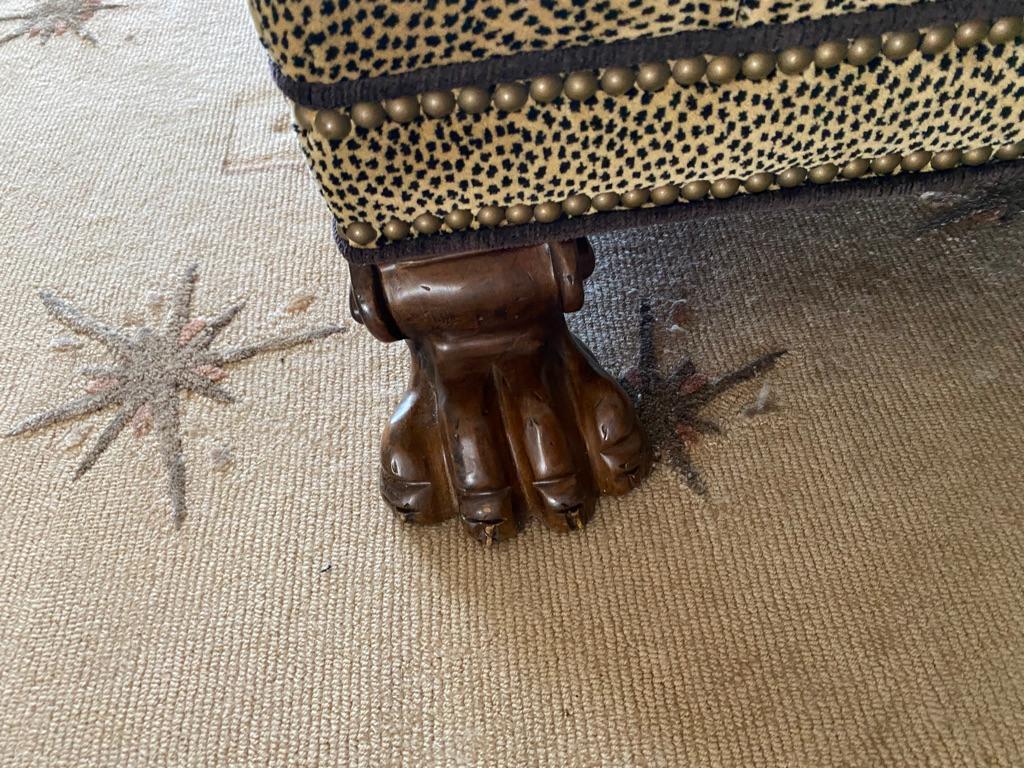 This modern foot stool is made and mahogany carved feet upholstered i spotted fabric and nails trim the sides wider than most! This piece came from an Estate on park Avenue.
