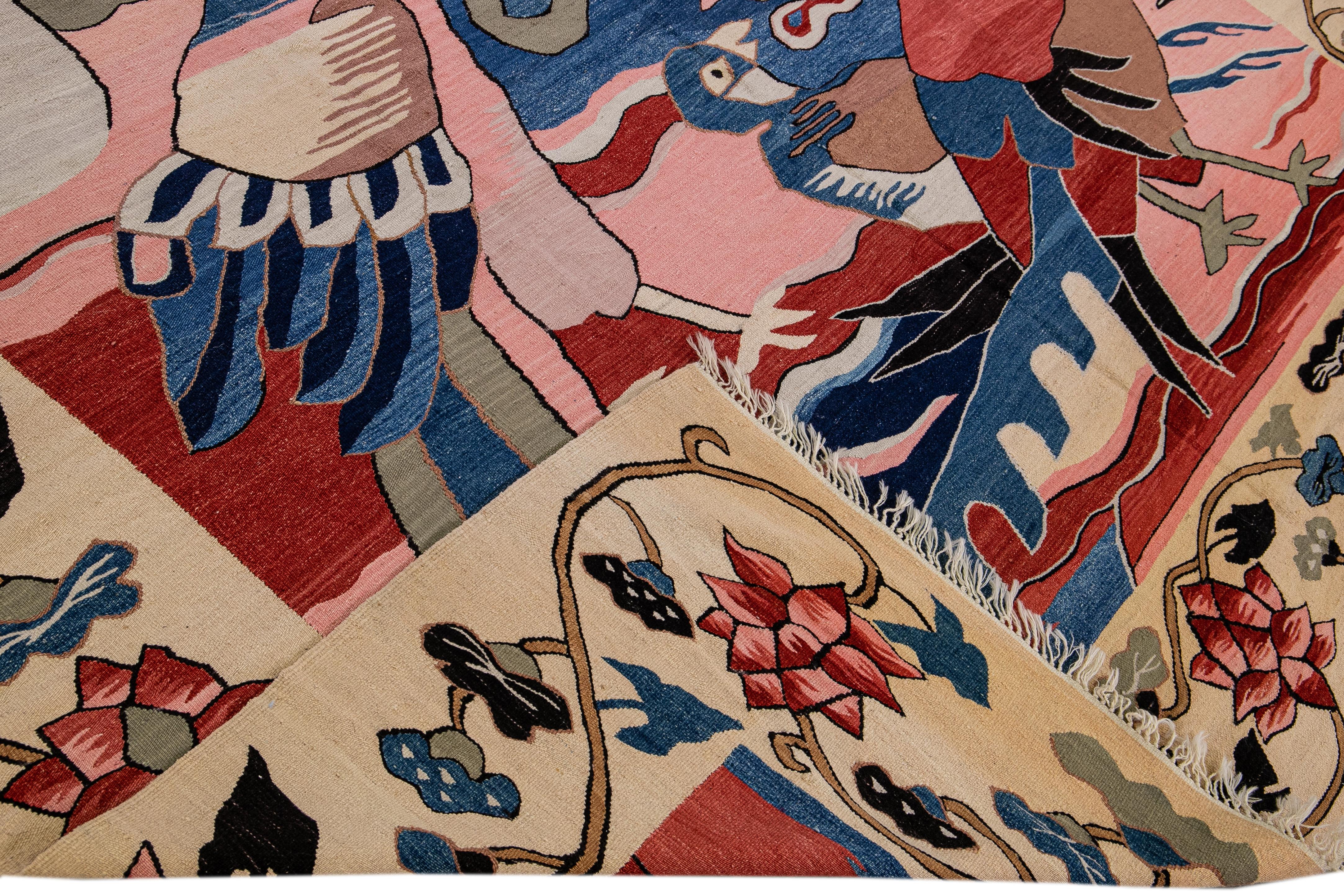 Schöner moderner flachgewebter Kelim-Wollteppich mit einer rosa, roten, beigen und blauen Feldaufteilung in einem herrlichen Pfauen-Volks- und Kunstmotiv-Design.

Dieser Teppich misst: 9' x 12'.

Unsere Teppiche werden vor dem Versand