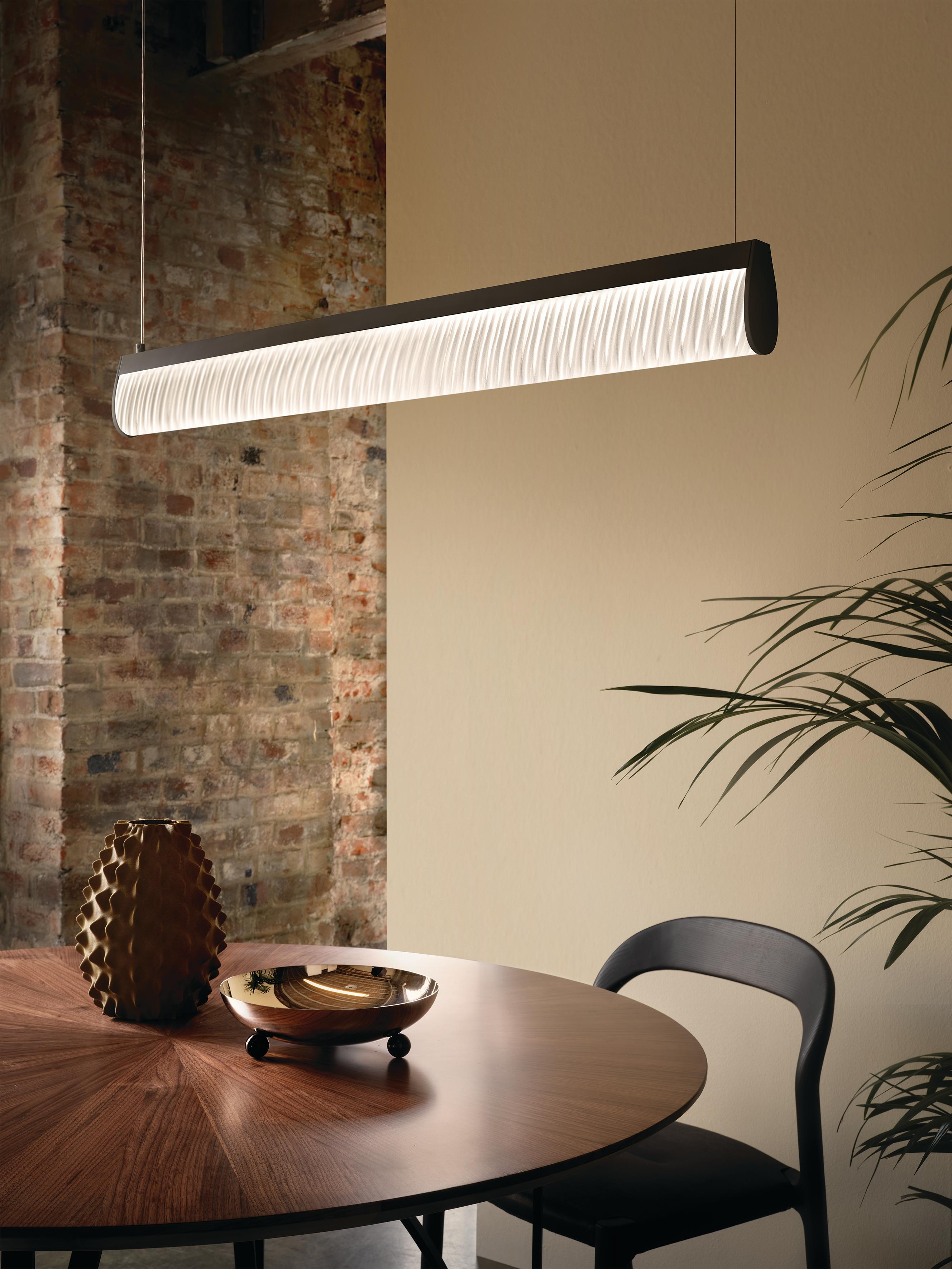 Modula is a versatile collection that creates unexpected plays of light. Columns from Medieval cloisters inspired a Plissé effect, and sparkling stones are reflected in a Crystal effect, each taking a lamp that is outwardly minimal to an explosion
