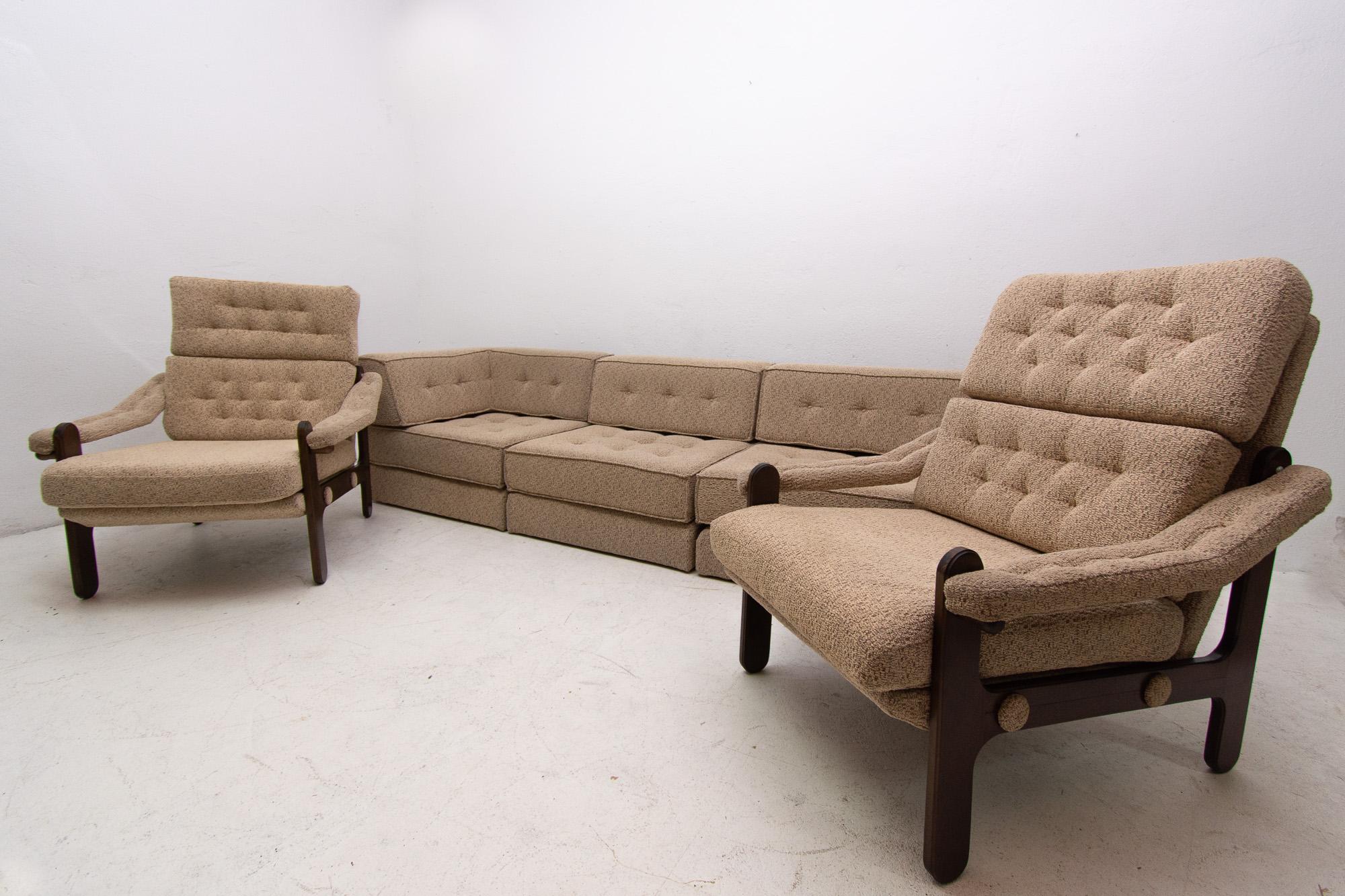 This lounge modular seating group was made in the 1980s in the former Czechoslovakia. Consists of one sofa and two armchairs. The set is upholstered in fabric. The structure is made of wood. The sofa can be divided into three separated seats. The