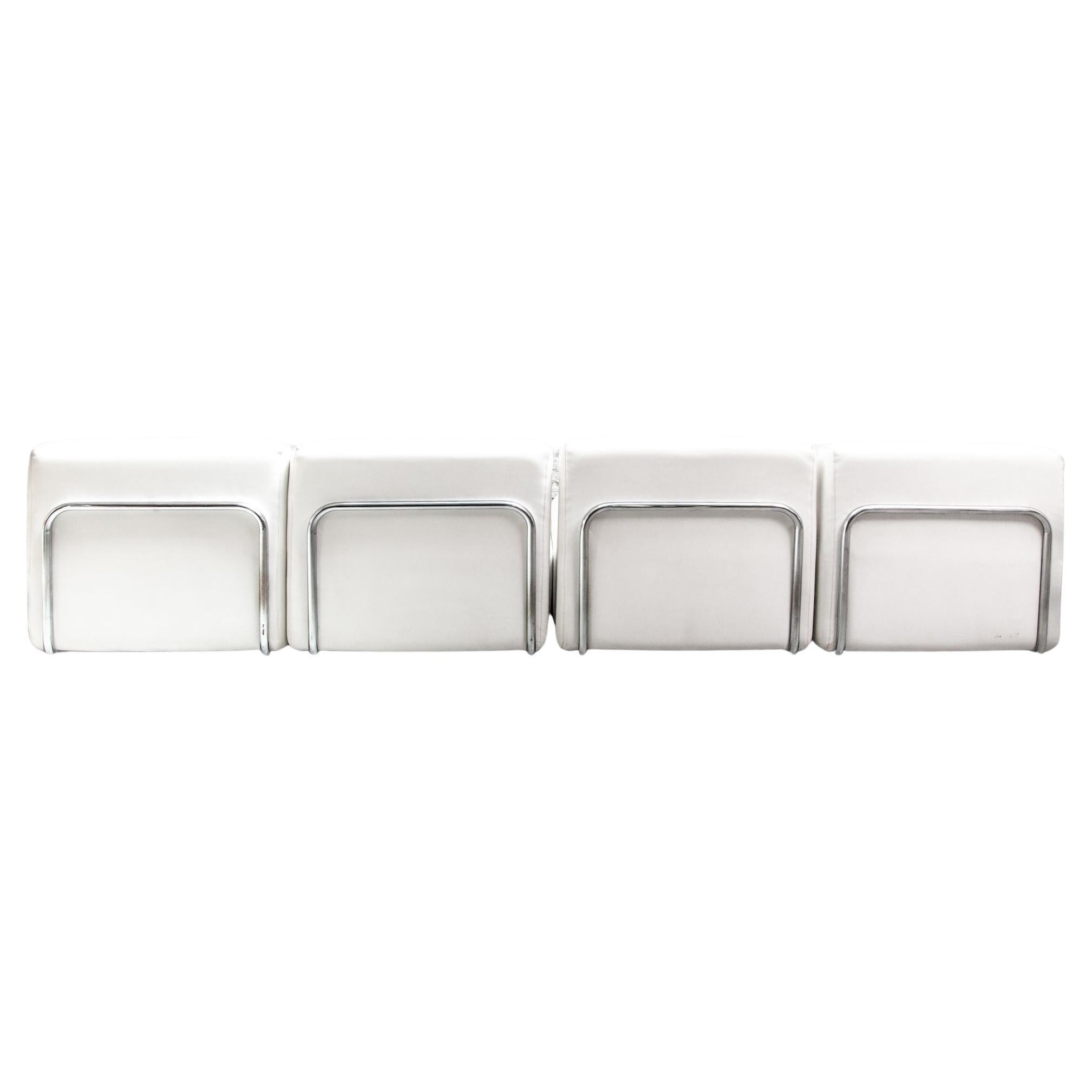 A living-room set of Adriano Piazzesi, Italian 1960's. Beautiful white tufted faux leather lounge chairs, corners and footstools, with chrome-plated tubular steel curved supports in front and back sides, the front and back tubes showcasing the seats