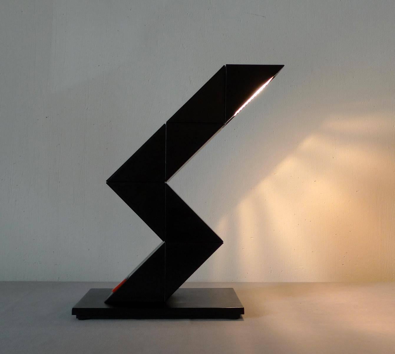 Nicely designed lamp by E-lite (Netherlands)
The lamp can twist and turn the light into different shapes. Kubist/Triangles, neat design. Matte black arm.

The lamp can be manipulated via turning the plastic blocks to an amazing number of