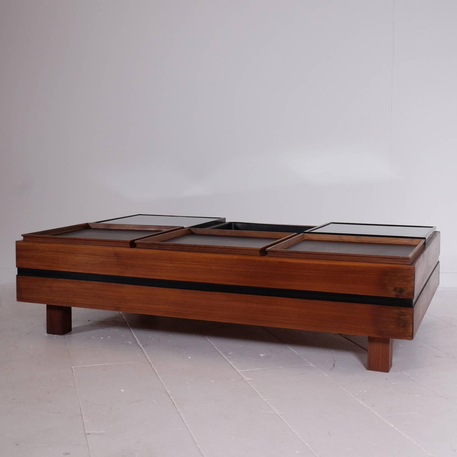 Produced by Sormani, pair of coffee tables, wood, glass, Italy, 1960s.

Architectural coffee table executed with six square elements each. The tables consist of a one empty element, two glass element and two wooden elements. The base of the table