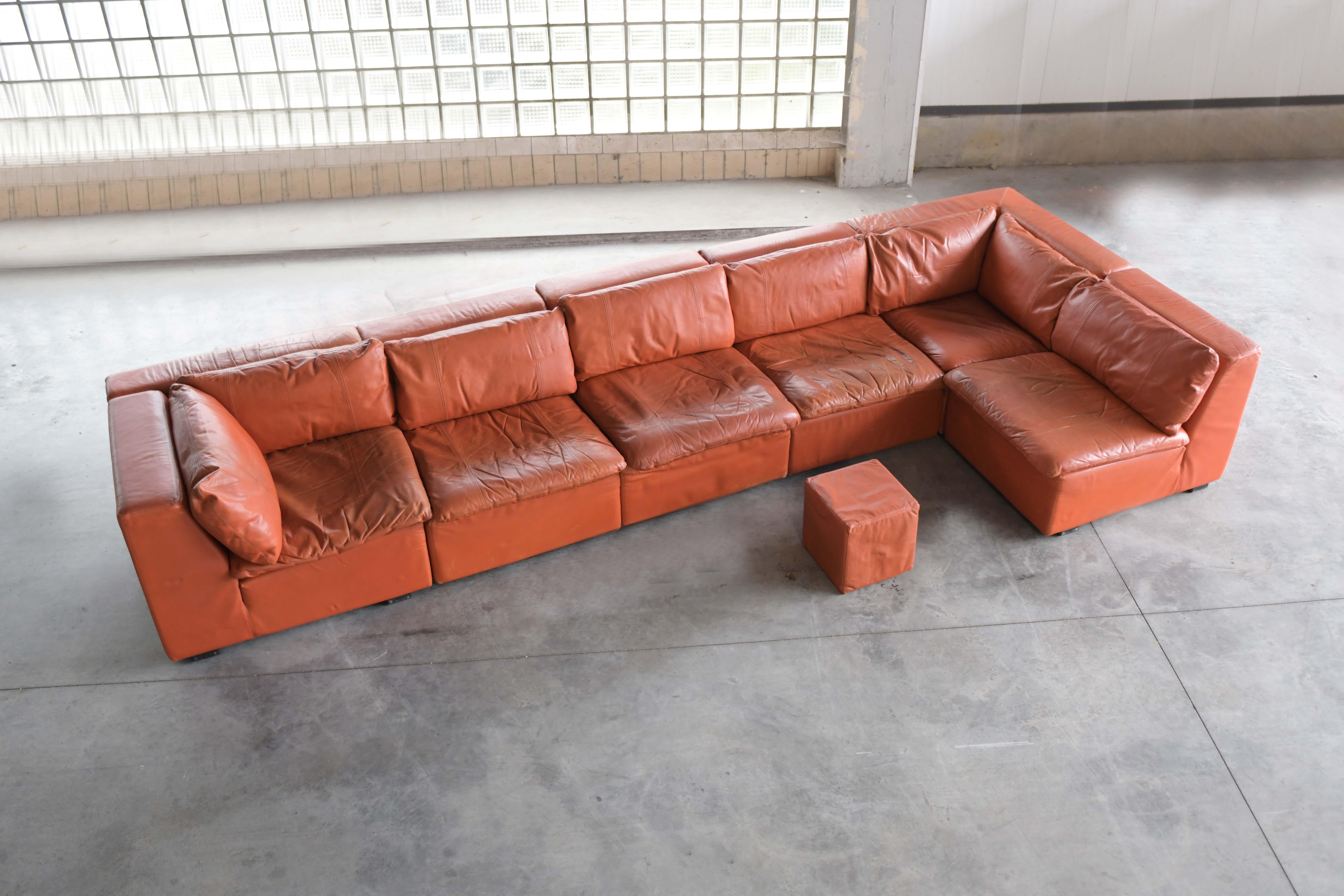 Very rare modular sofa in his original orange leather. 
With labels and printed name on the feet.

Nice vintage condition (check pictures)
Only sold as a set : 2 corners + 4 ‘1-seats’ + poof + 3 cushions.