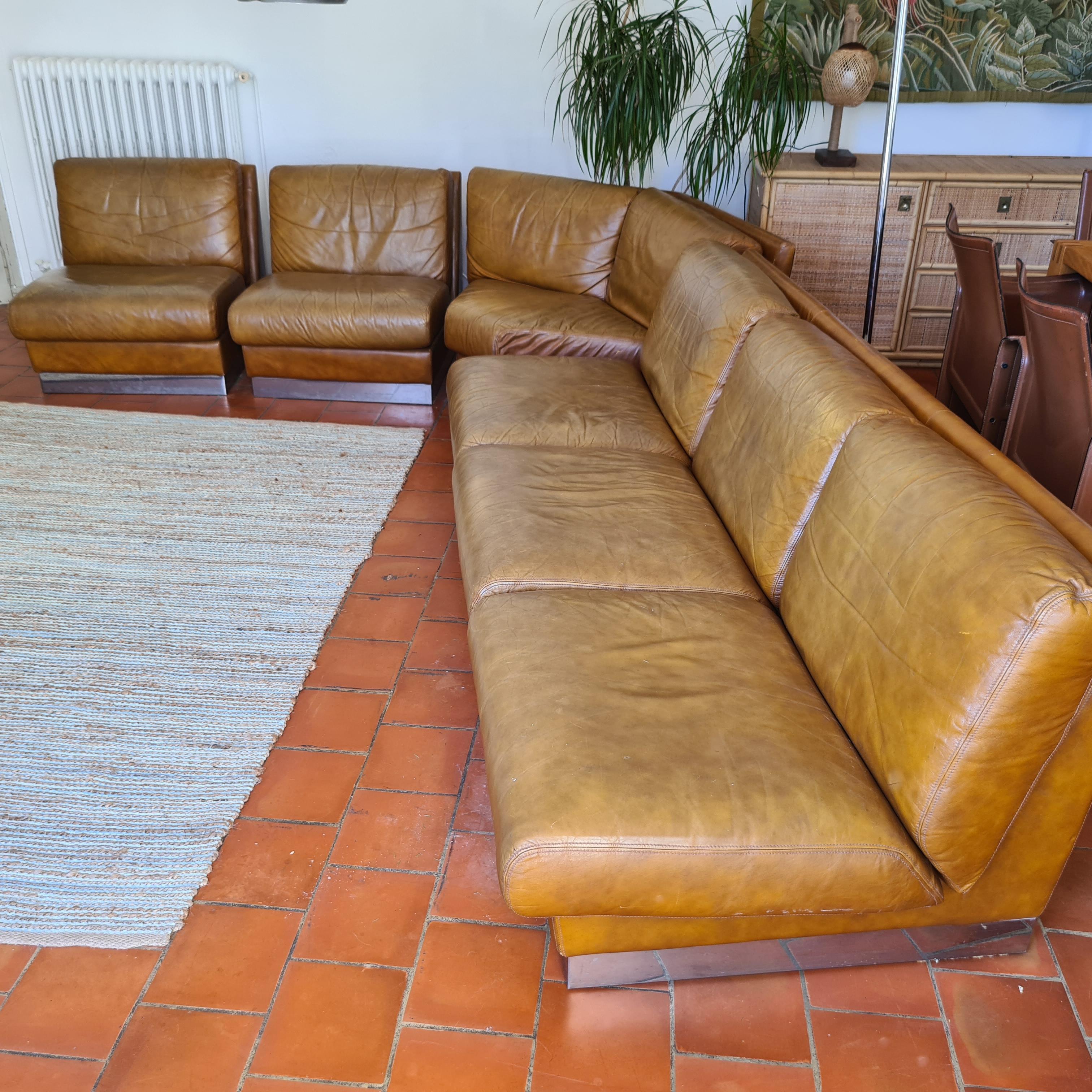 Canapé modulaire en cuir et acier de Jacques Charpentier circa 1970 composé d'un canapé 3 places, de 2 fauteuils et d'un module d'angle. Canapé 3 places : 210L x 88P x 69H cm Fauteuil : 70L x 88P x 69H cm Module d'angle 154L x 75P x 69H cm.