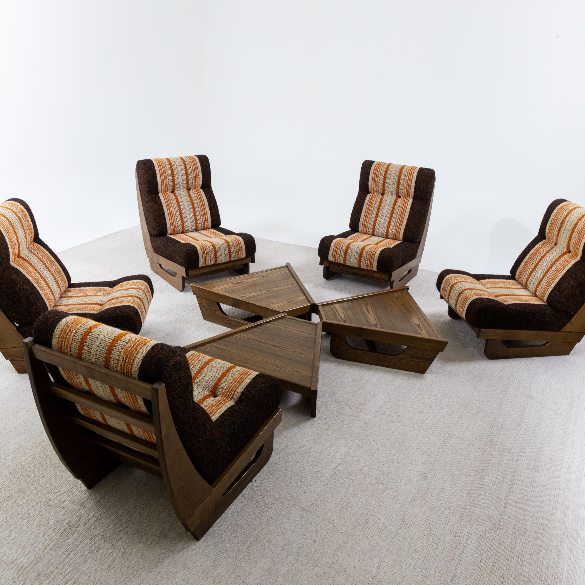 Modular seating group with five lounge chairs and three tables made of wood. The combination can be varied at will. Due to the trapezoidal shape of the coffee tables, the group can also be arranged in a semicircle. The original seat cushions with