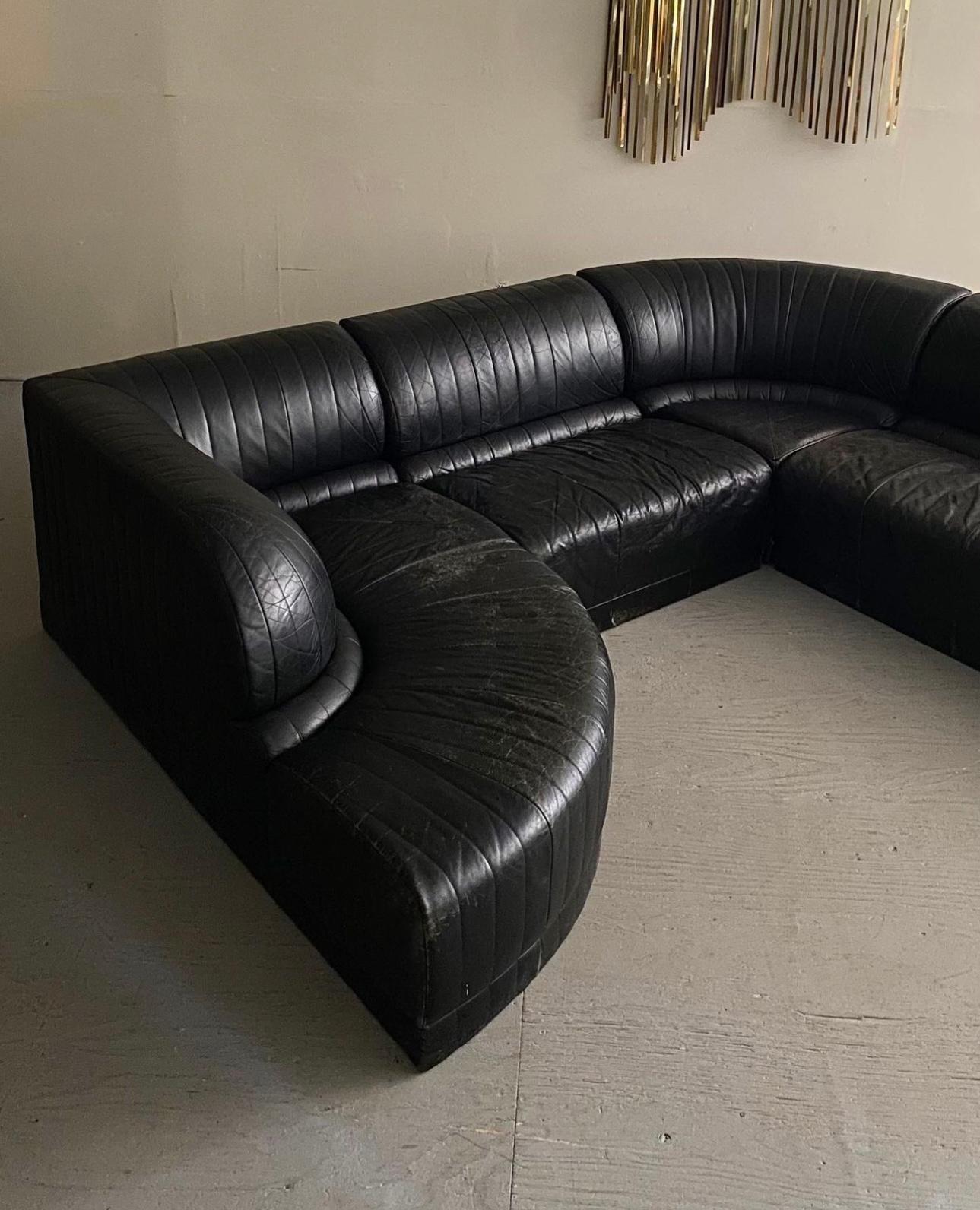 Modular Serpentine Sofa By Roche Bobois, 1983. Sectional features 5 sections, all with channeled stitching, and wrapped in their original patinated black leather upholstery. The sections can be configured in a number of ways to suit ones needs.