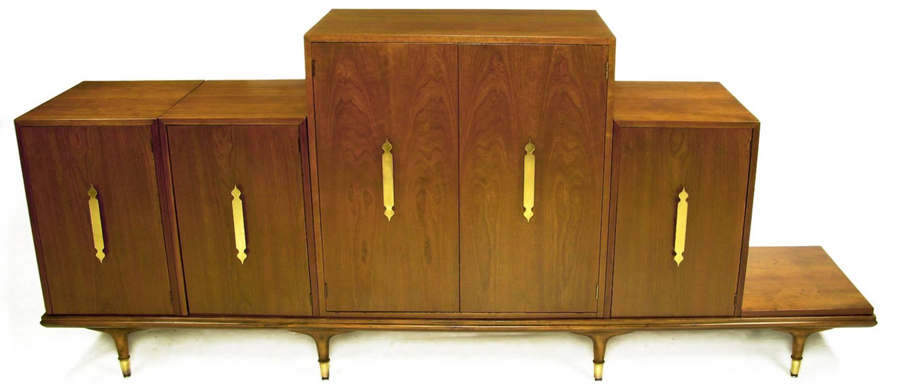 Very rare and unusual piece by Edward Wormley. This modular credenza in walnut can be put together in a host of different configurations. Detailed with large Moorish style solid brass pulls and brass sabots.